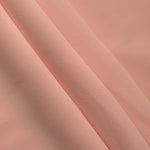Rose Beige mechanical polyester crepe in layered folds, showing gentle stretch and structure for dressmaking