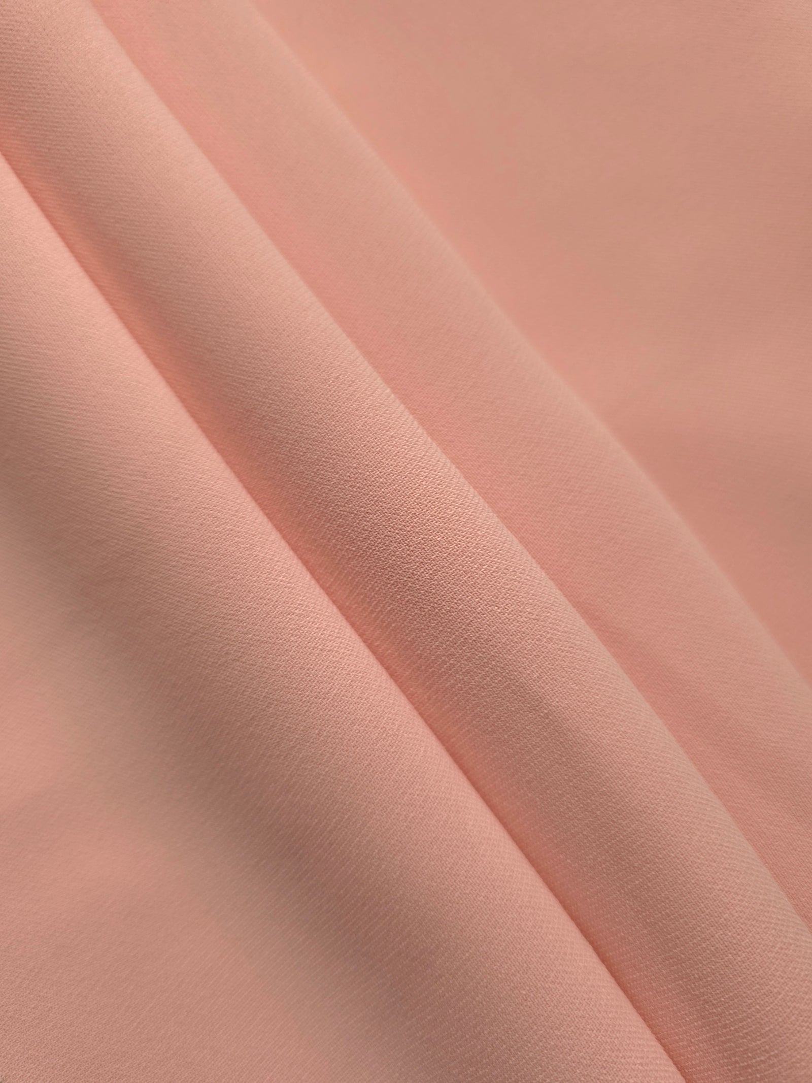 Rose Beige mechanical polyester crepe in layered folds, showing gentle stretch and structure for dressmaking