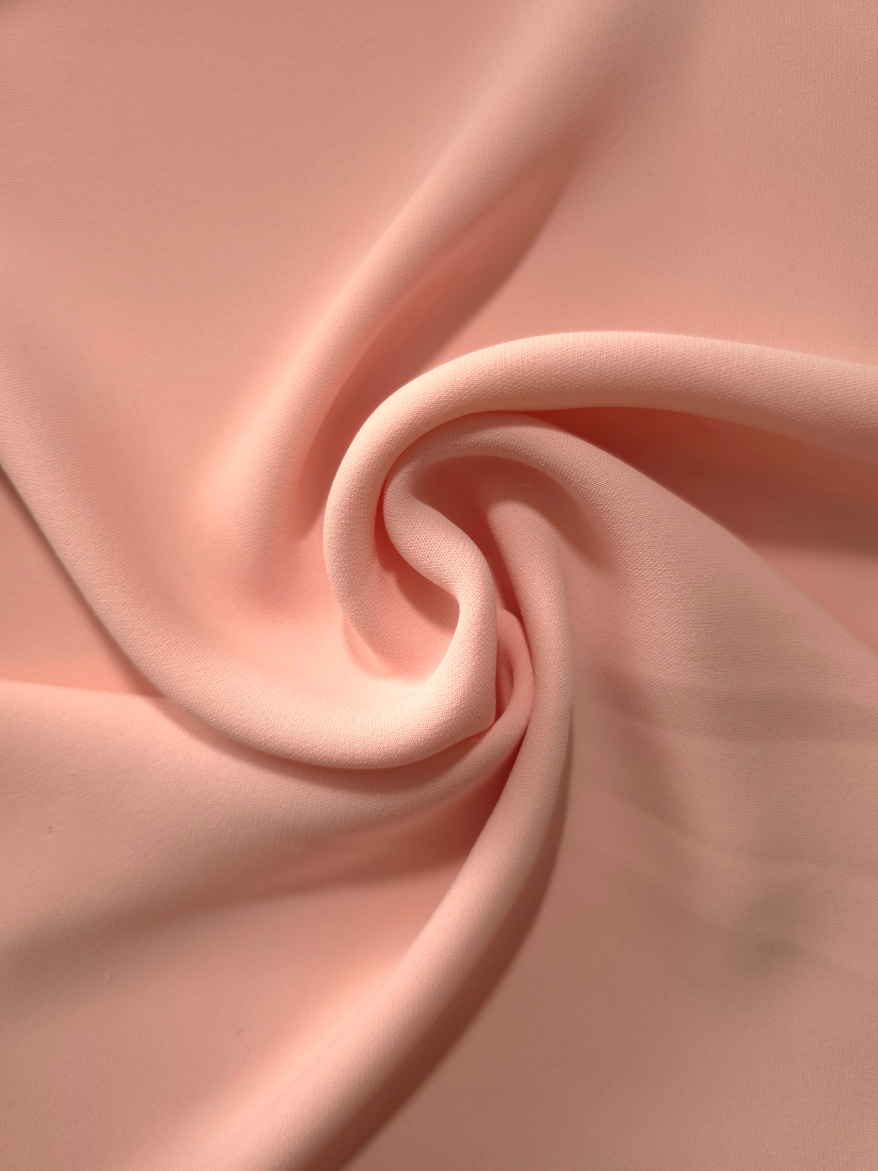 Spiral styling of Rose Beige Korean polyester crepe showing supple drape for abayas, dresses and occasionwear