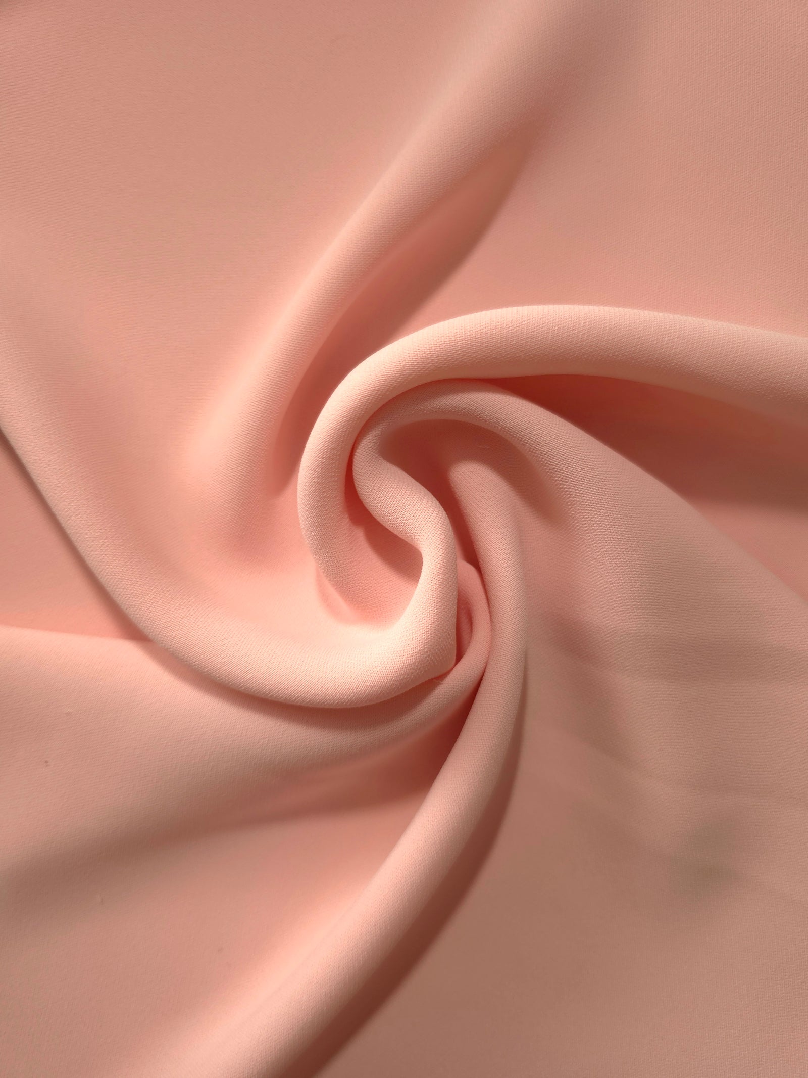 Spiral styling of Rose Beige Korean polyester crepe showing supple drape for abayas, dresses and occasionwear