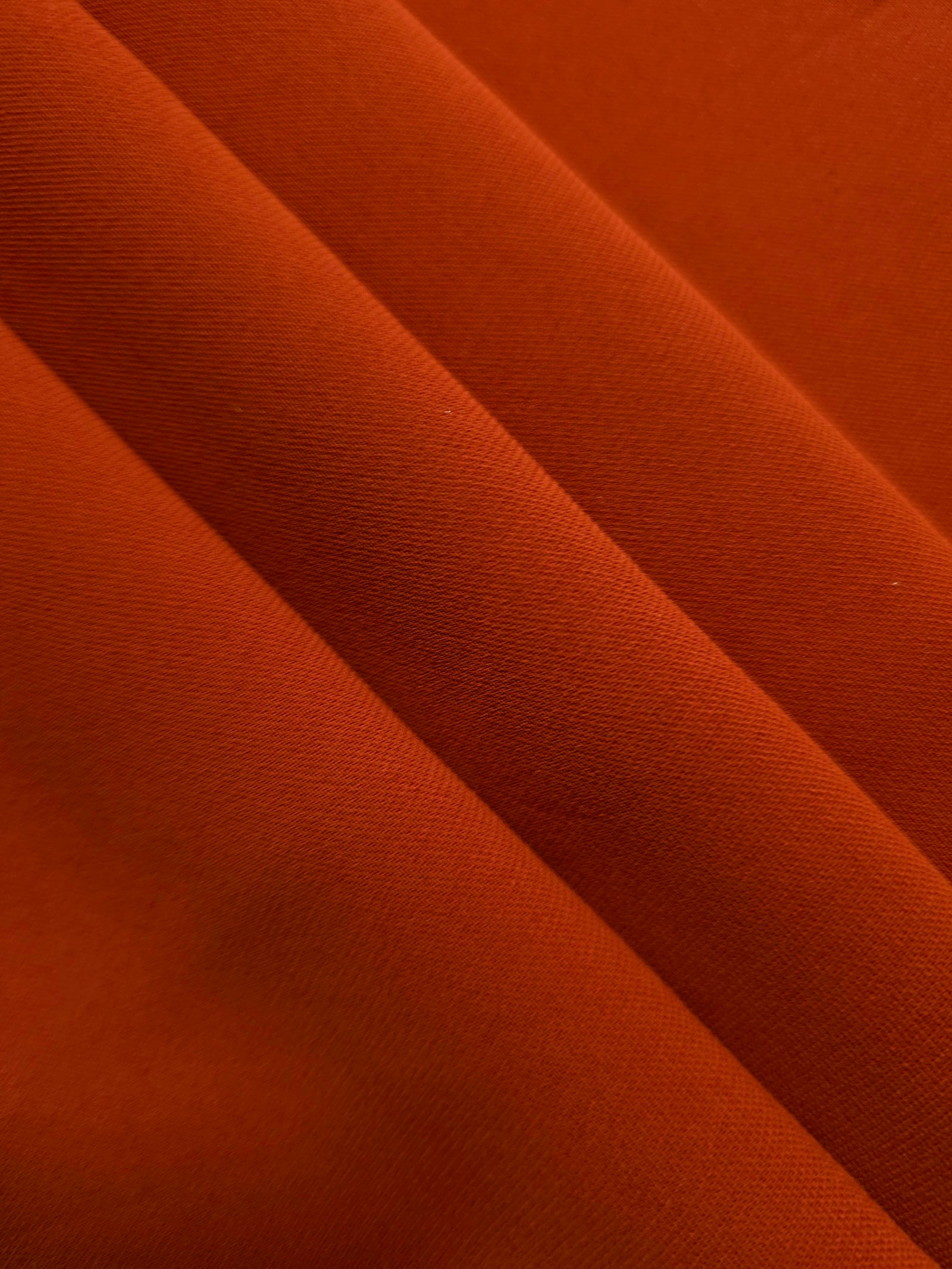 Rust Orange mechanical polyester crepe layered to show soft structure for tailored garments and separates