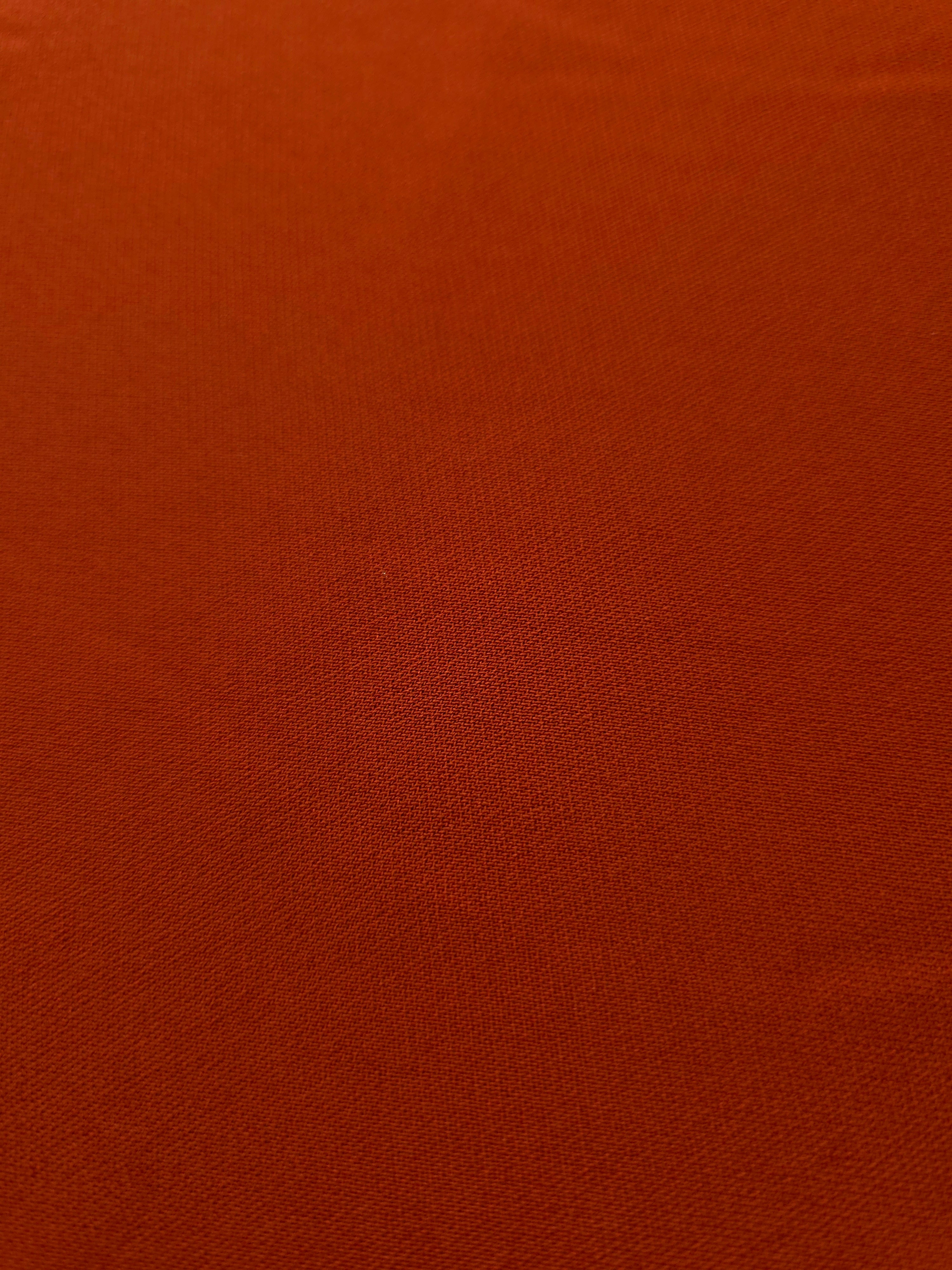 Close woven detail of Rust Orange 100% polyester Korean crepe showing its smooth texture and soft finish