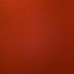 Surface view of Rust Orange 205 GSM polyester crepe, opaque Korean dress fabric with a smooth woven finish