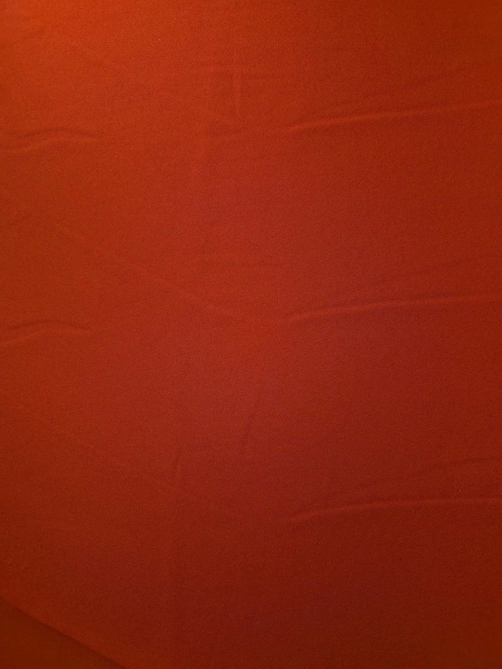 Surface view of Rust Orange 205 GSM polyester crepe, opaque Korean dress fabric with a smooth woven finish