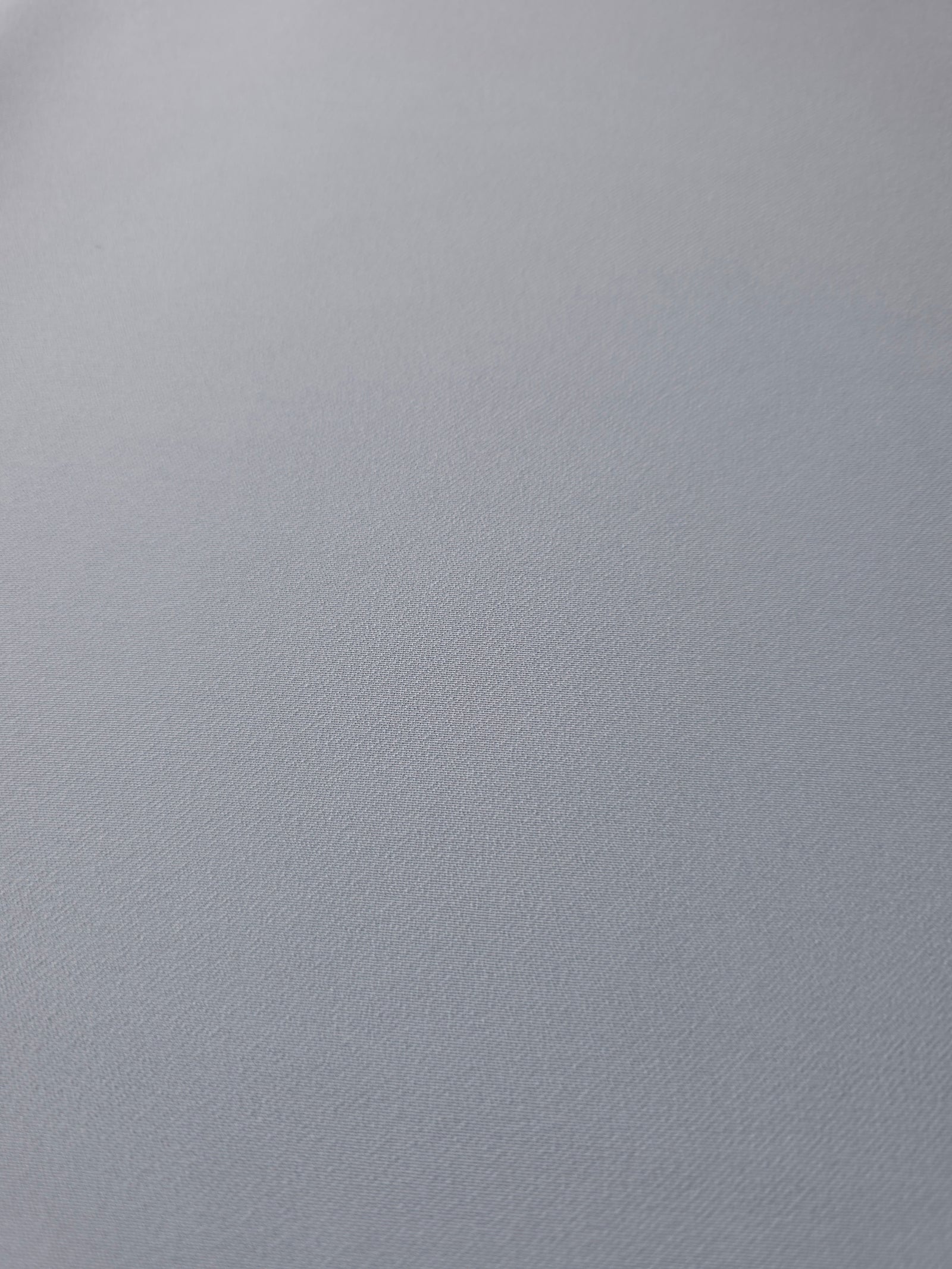 Close woven detail of Silver Blue 100% polyester Korean crepe showing its smooth texture and soft finish