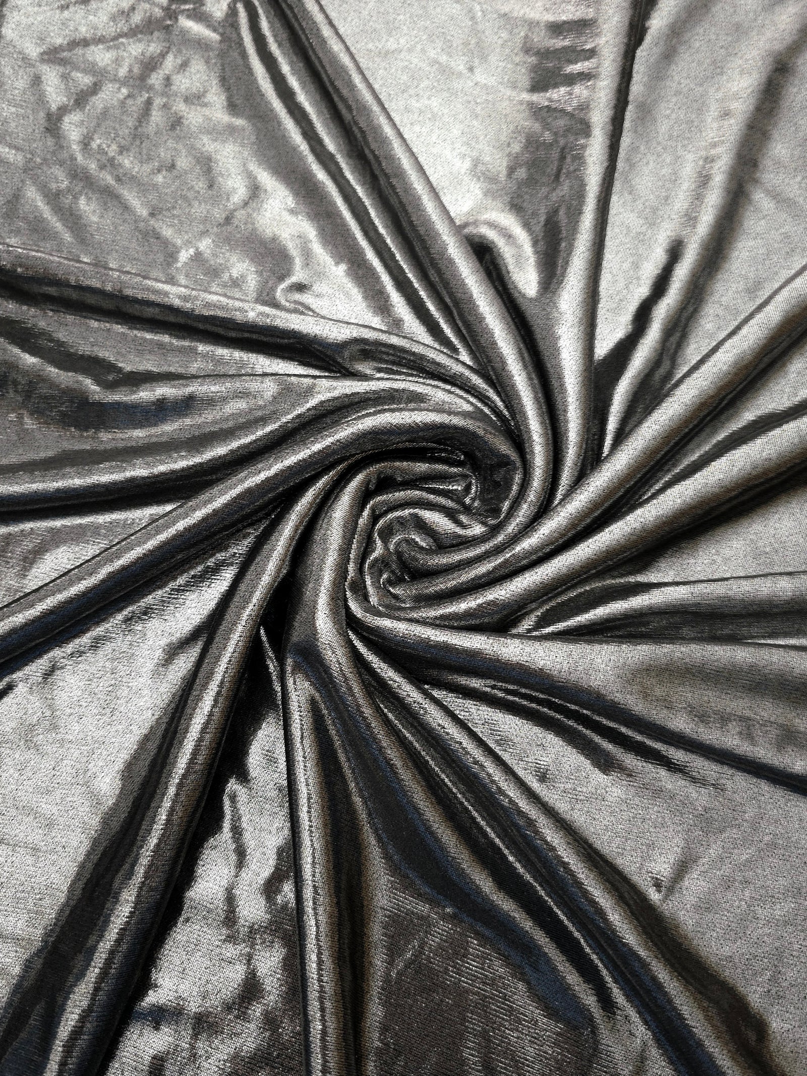 Flowing swirl of Silver Gray metallic stretch fabric, showing dynamic foil reflection for stagewear, skirts and creative fashion