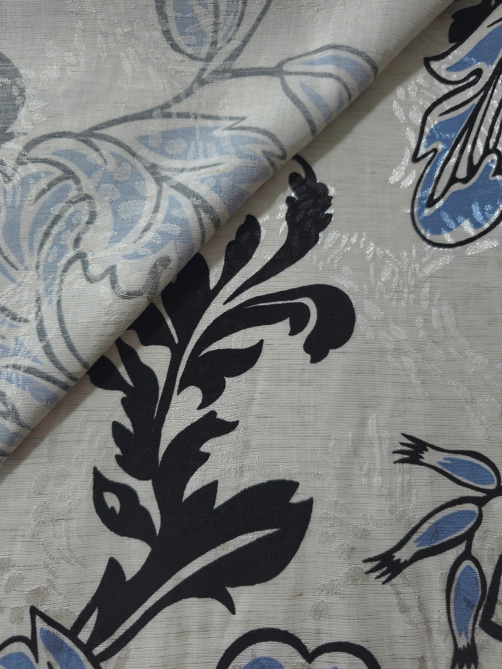 Blue sketch floral jacquard fabric close-up detail showing woven flower texture.