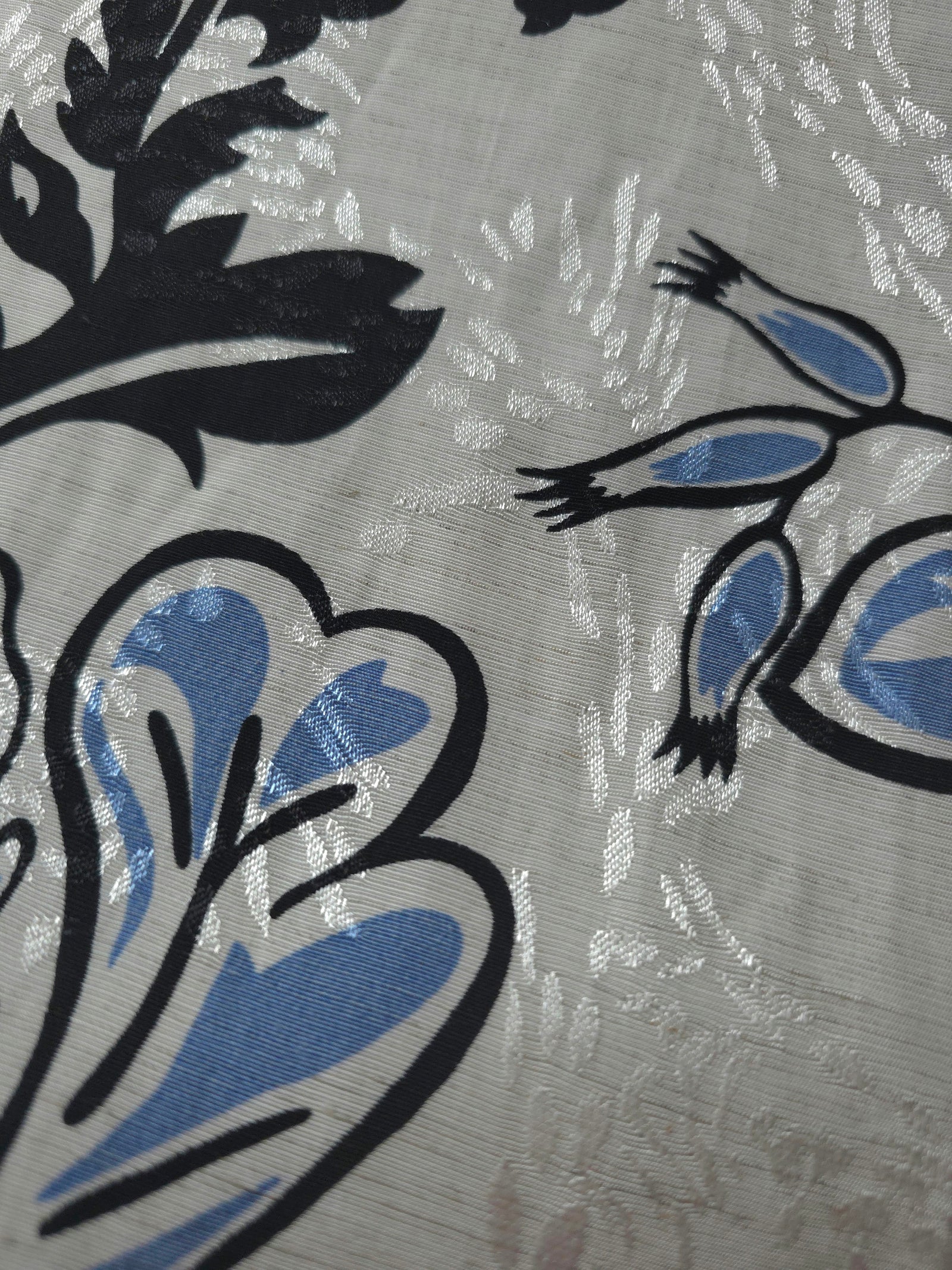 Texture view of blue sketch floral jacquard fabric with woven floral design.