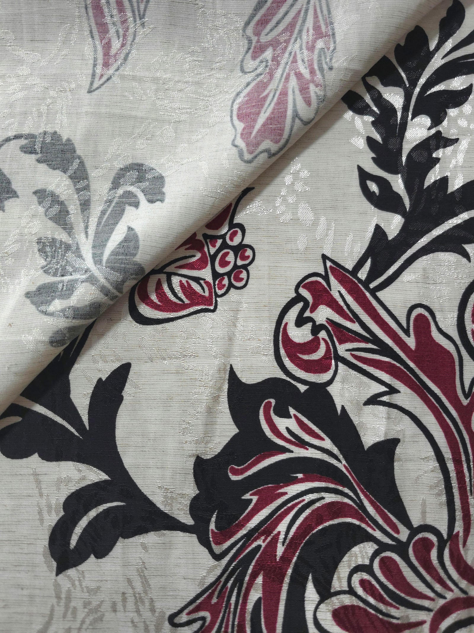 Deep red sketch floral jacquard fabric close-up showing woven flower texture.