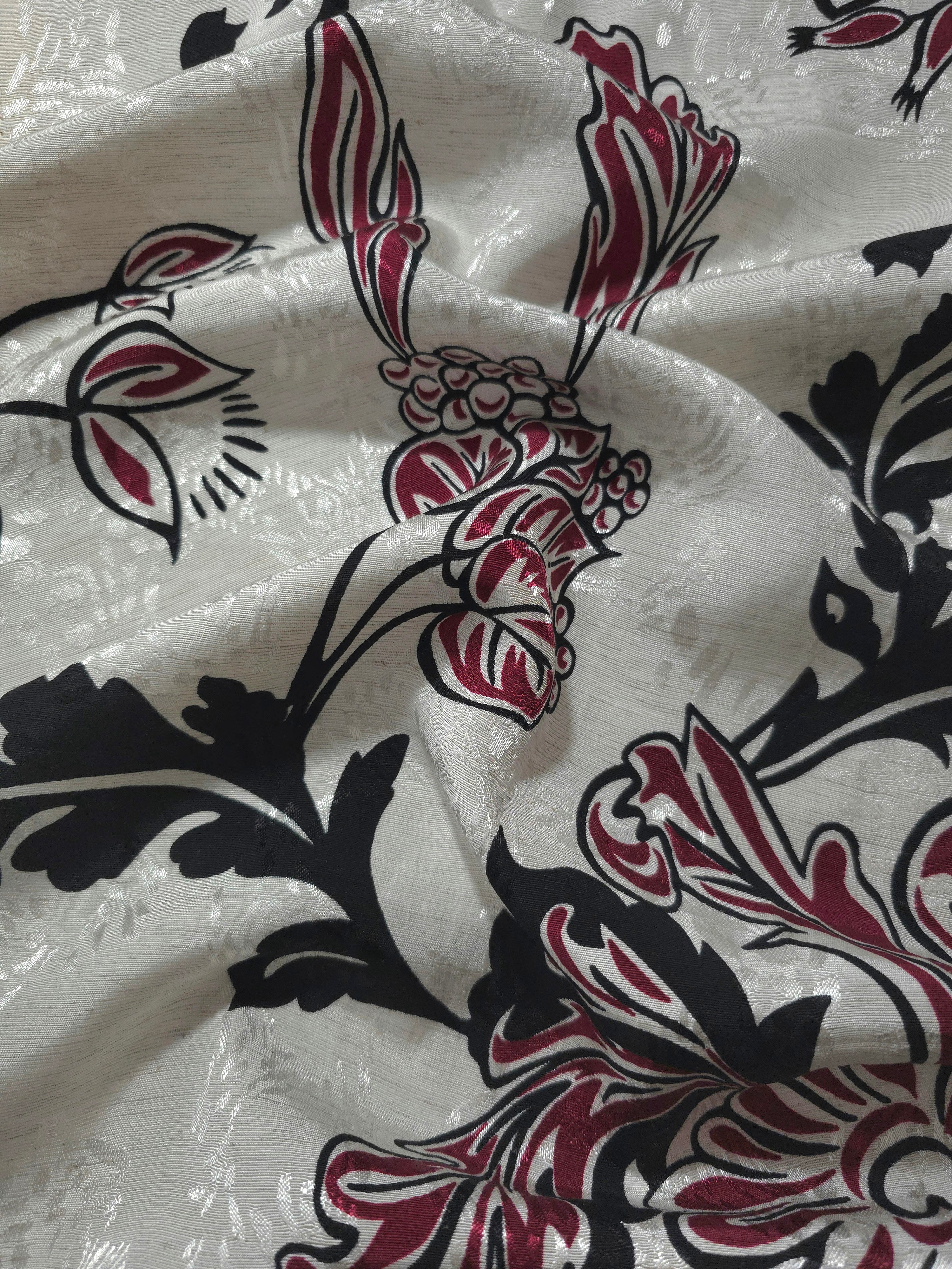 Deep red sketch floral jacquard fabric draped to show apparel movement and woven floral design.