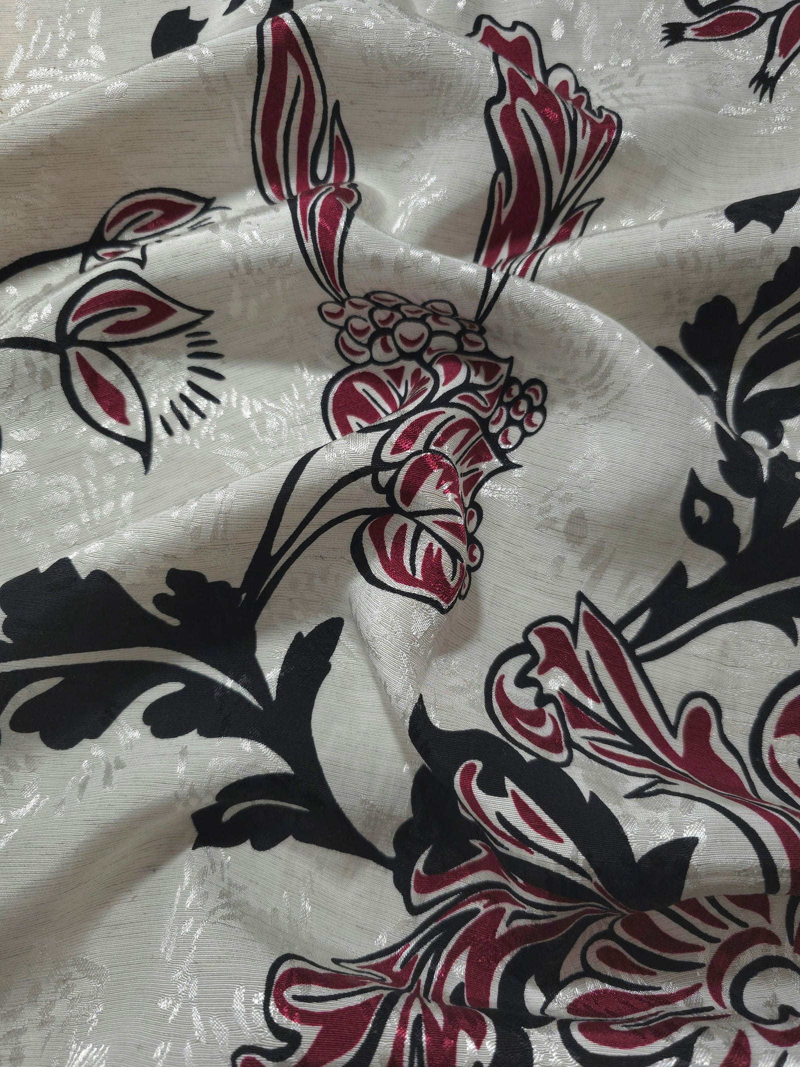 Deep red sketch floral jacquard fabric draped to show apparel movement and woven floral design.