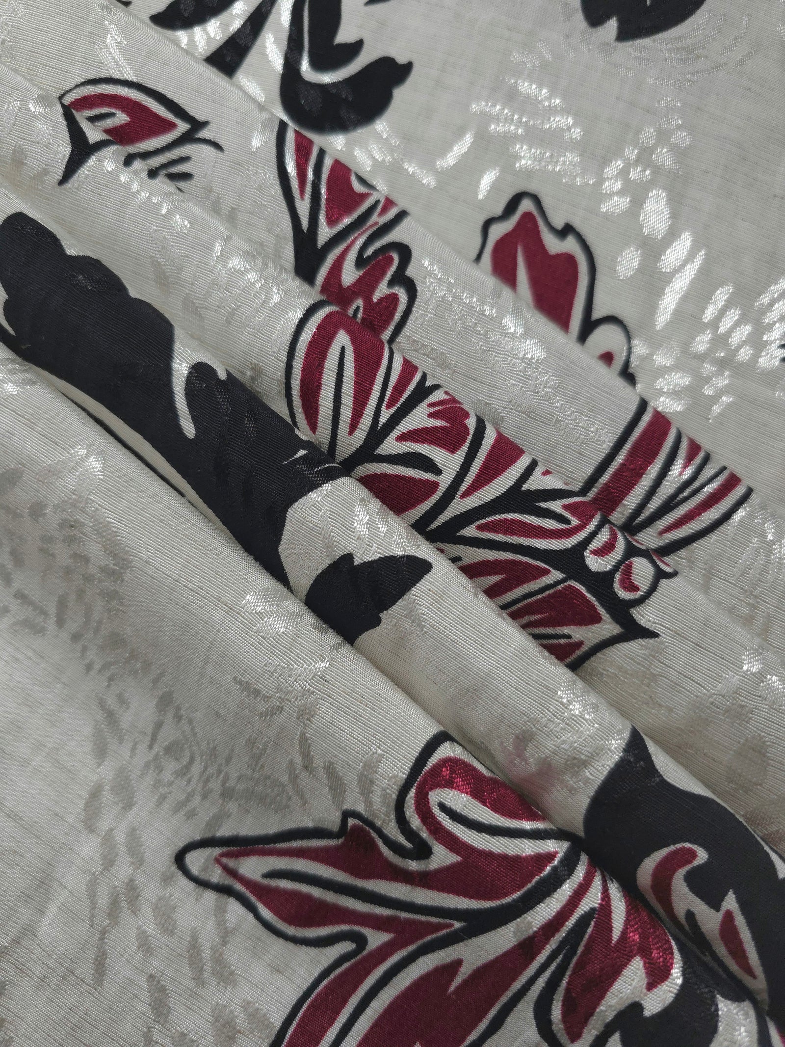 Reverse side of deep red sketch floral jacquard fabric showing woven construction and texture.