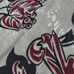 Texture view of deep red sketch floral jacquard fabric with woven flower motif.