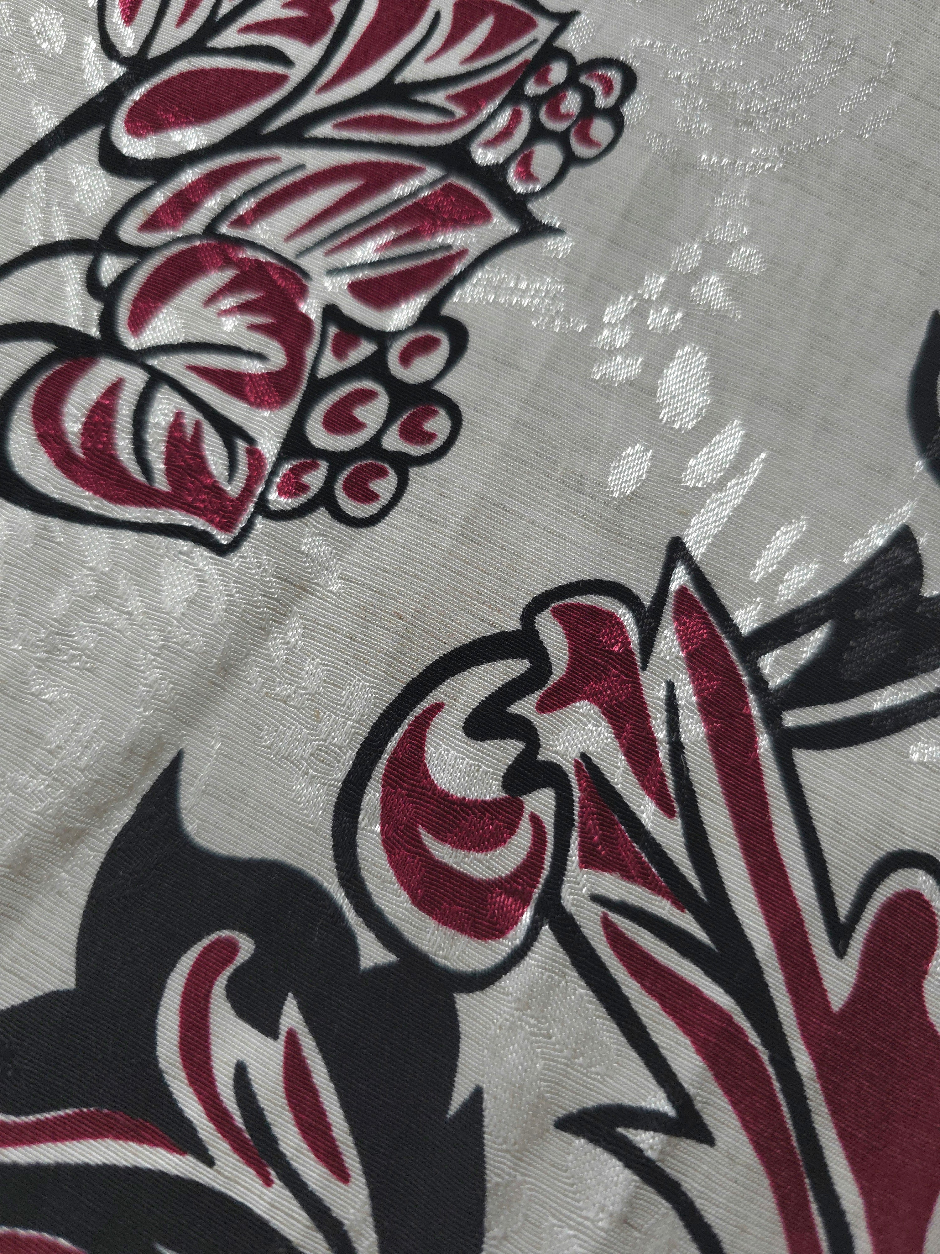 Texture view of deep red sketch floral jacquard fabric with woven flower motif.