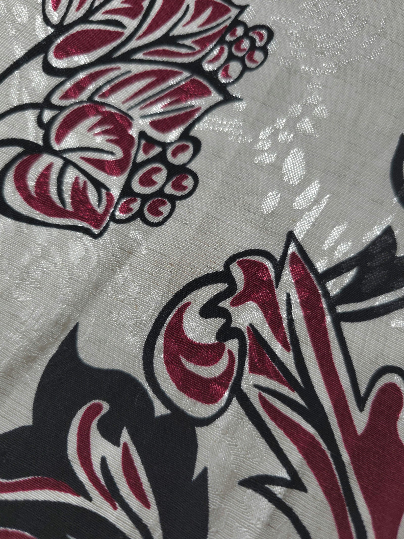 Texture view of deep red sketch floral jacquard fabric with woven flower motif.