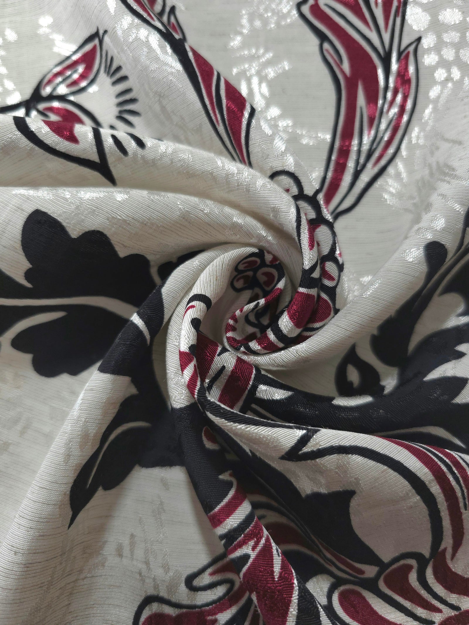 Deep red sketch floral linen-look jacquard fabric folded view showing soft structure and texture.