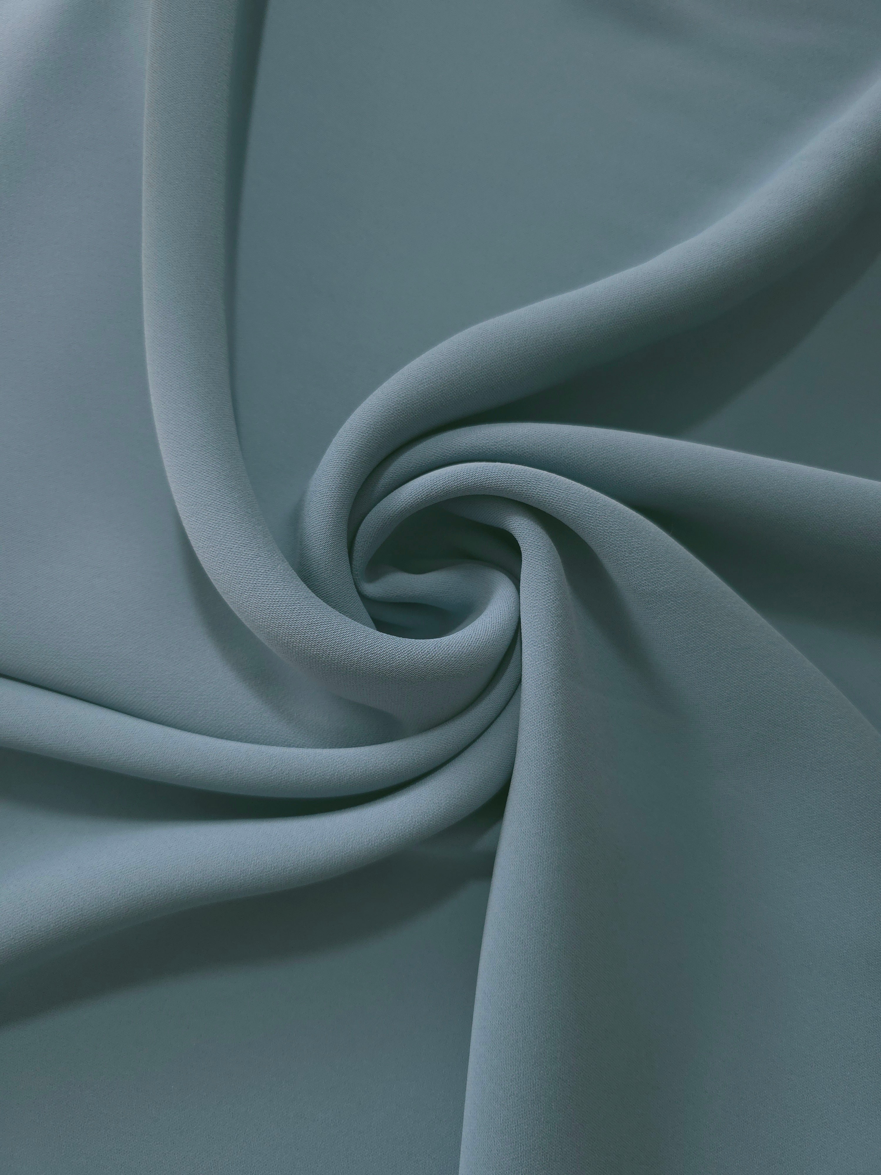 Circular drape of Slate Blue Gray polyester crepe showing flowing movement for occasion dresses and modest fashion