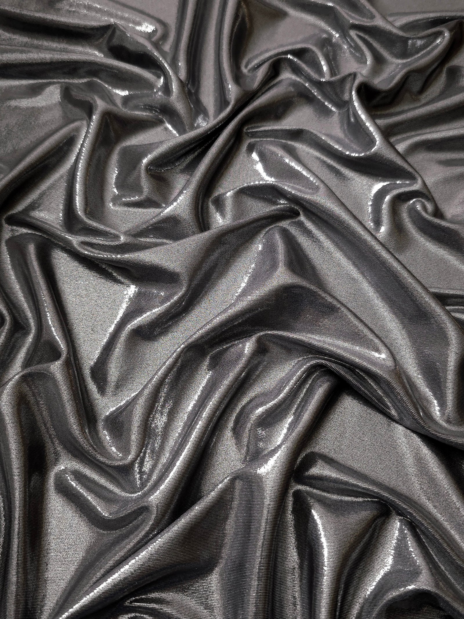 Smoky Gray metallic stretch fabric arranged in elegant folds, showing reflective movement for occasionwear, costumes and fashion design