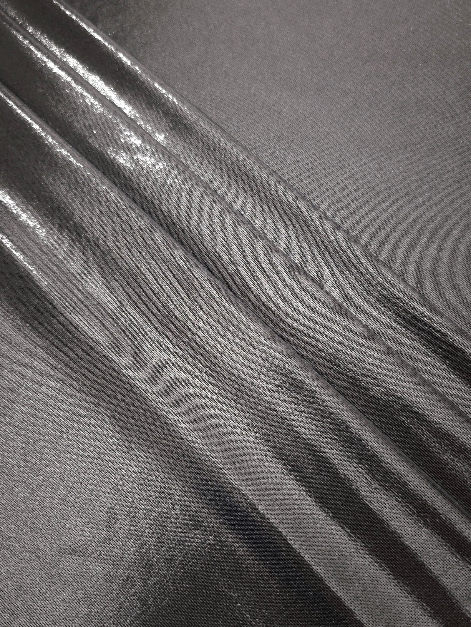 Layered Smoky Gray metallic stretch fabric with reflective foil finish, showing flexible body for dancewear and occasion fashion