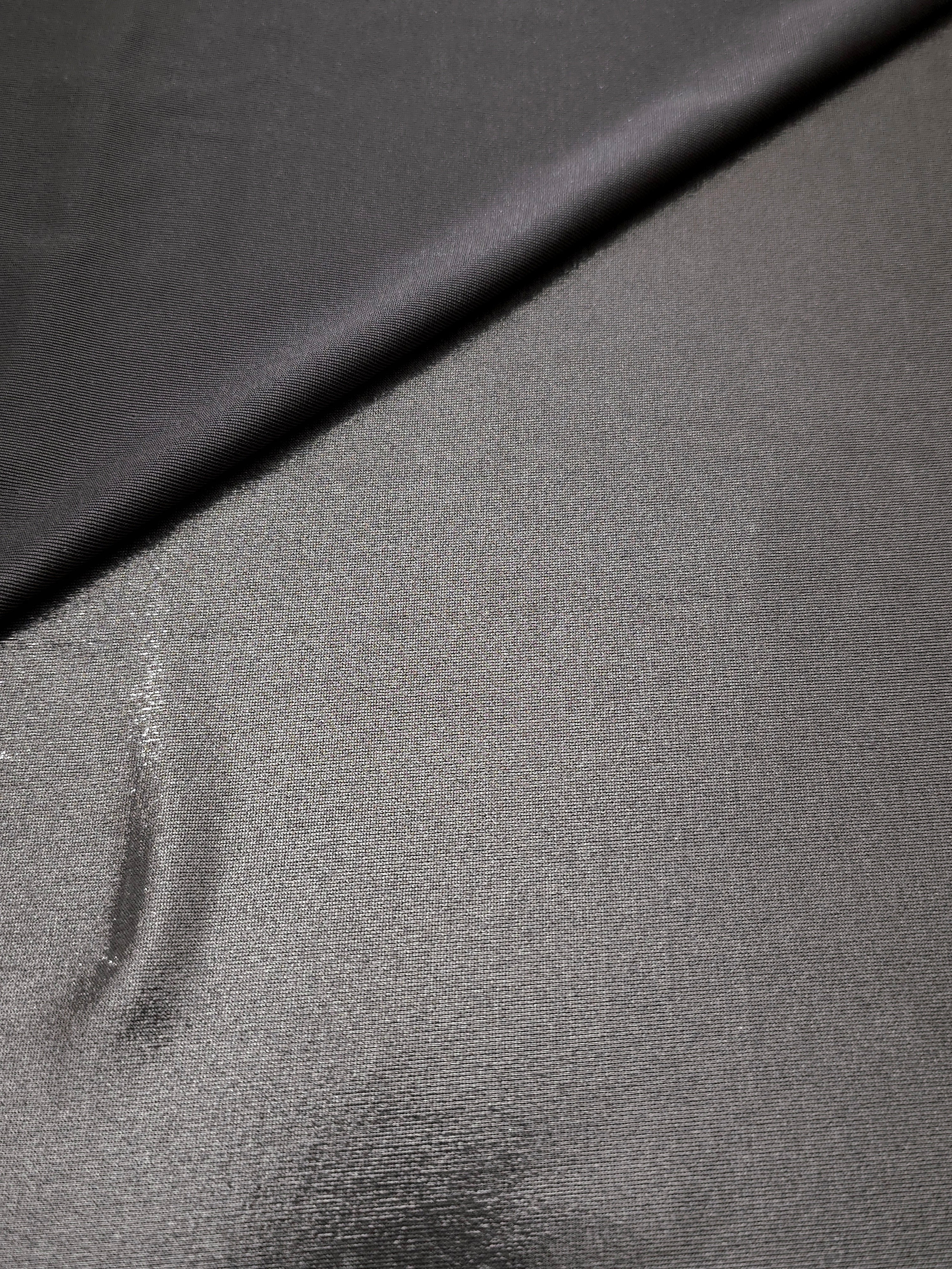 Smoky Gray metallic stretch fabric in a soft fold, revealing reflective drape for dancewear, dresses and statement apparel