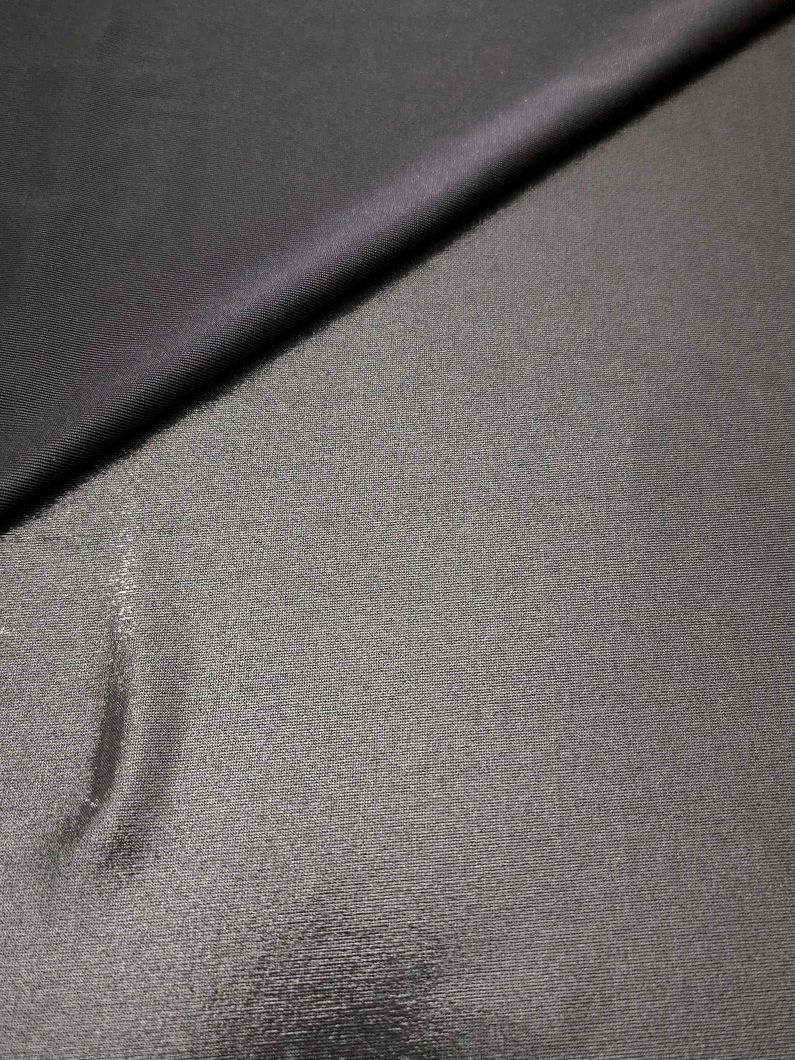 Smoky Gray metallic stretch fabric in a soft fold, revealing reflective drape for dancewear, dresses and statement apparel