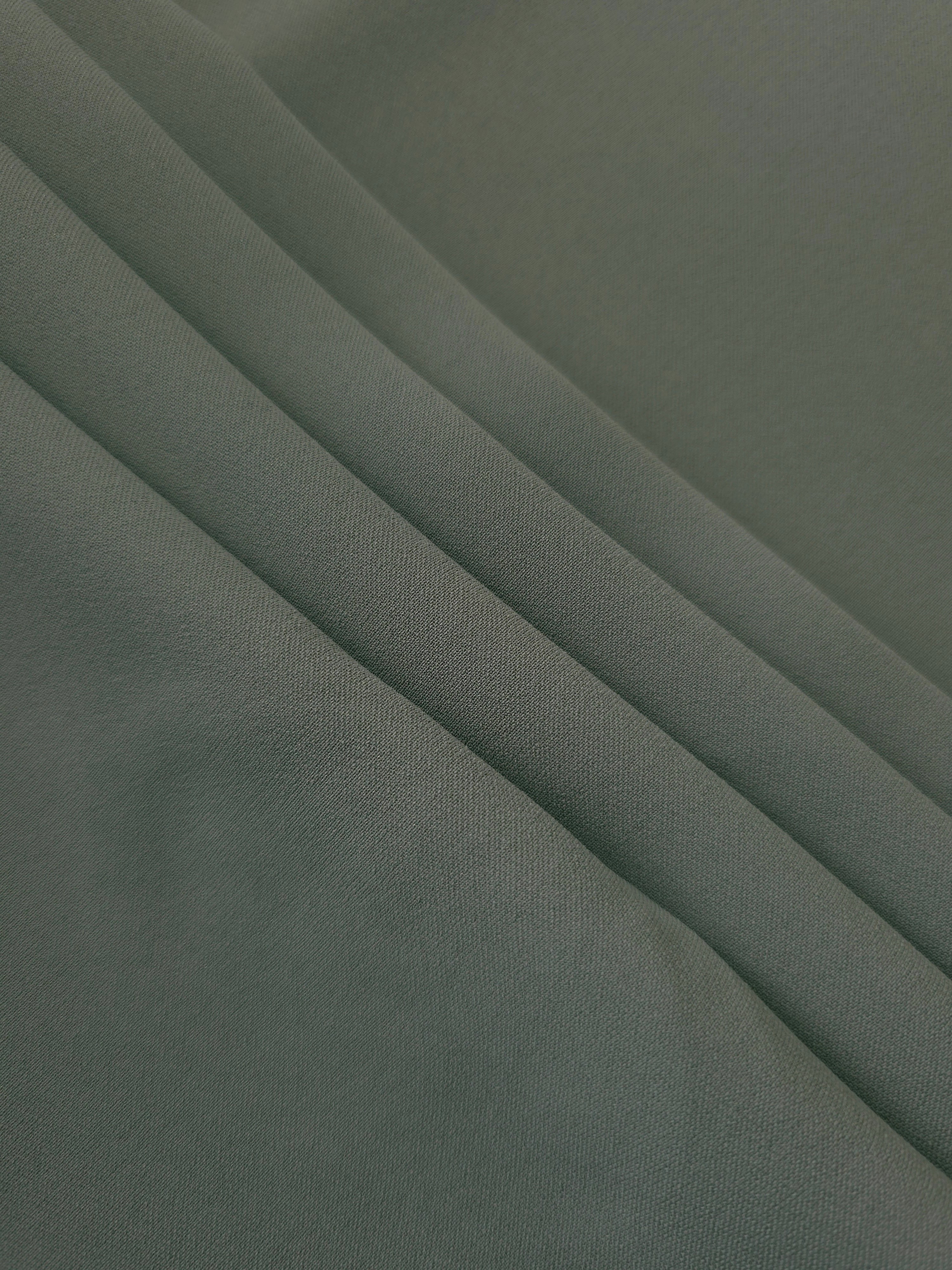 Smoky Sage Green Korean crepe in layered folds, showing soft structure and slight mechanical stretch for skirts
