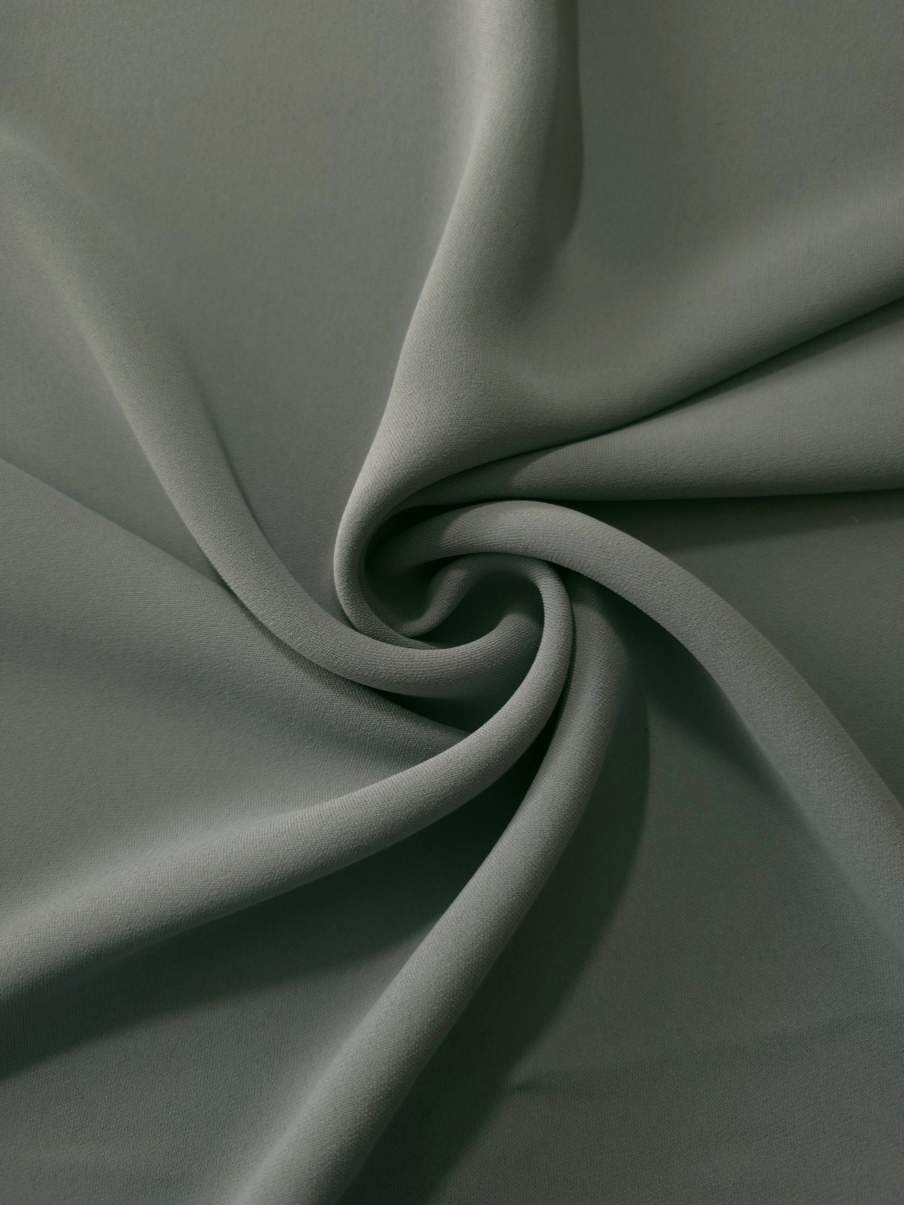 Swirled Smoky Sage Green Korean crepe showing fluid movement and silky drape for dresses and occasionwear