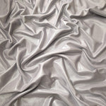 Draped Soft Silver Gray metallic foiled spandex showing reflective folds and flexible flow for dresses, stagewear and occasion looks