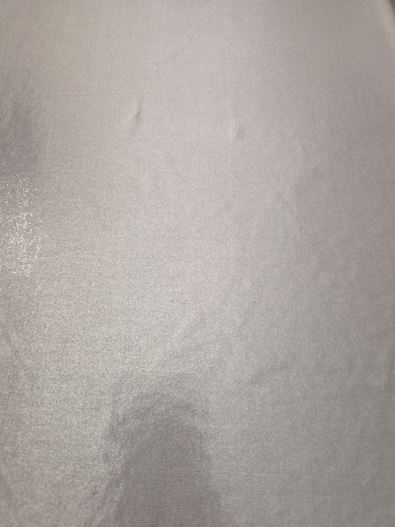 Soft Silver Gray metallic foiled spandex shown flat, reflective stretch fabric for dancewear, eveningwear and statement garments