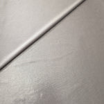 Soft Silver Gray shimmer spandex in a soft fold, showing metallic foil sheen and flexible drape for tops, skirts and costumes