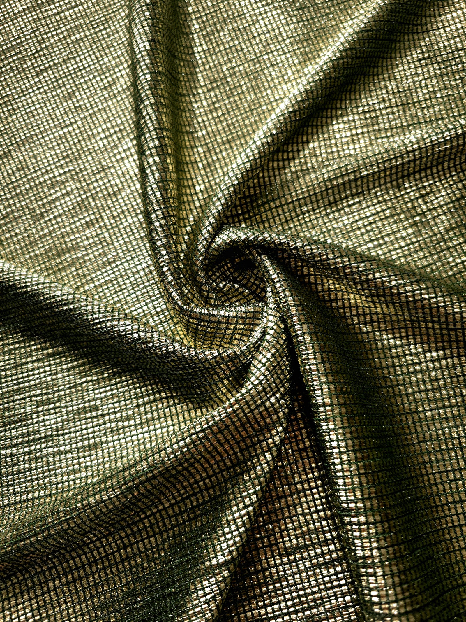Swirl-draped Antique Gold Sheer Square Shimmer Stretch Tulle Fabric showing structured square reflections moving through soft folds