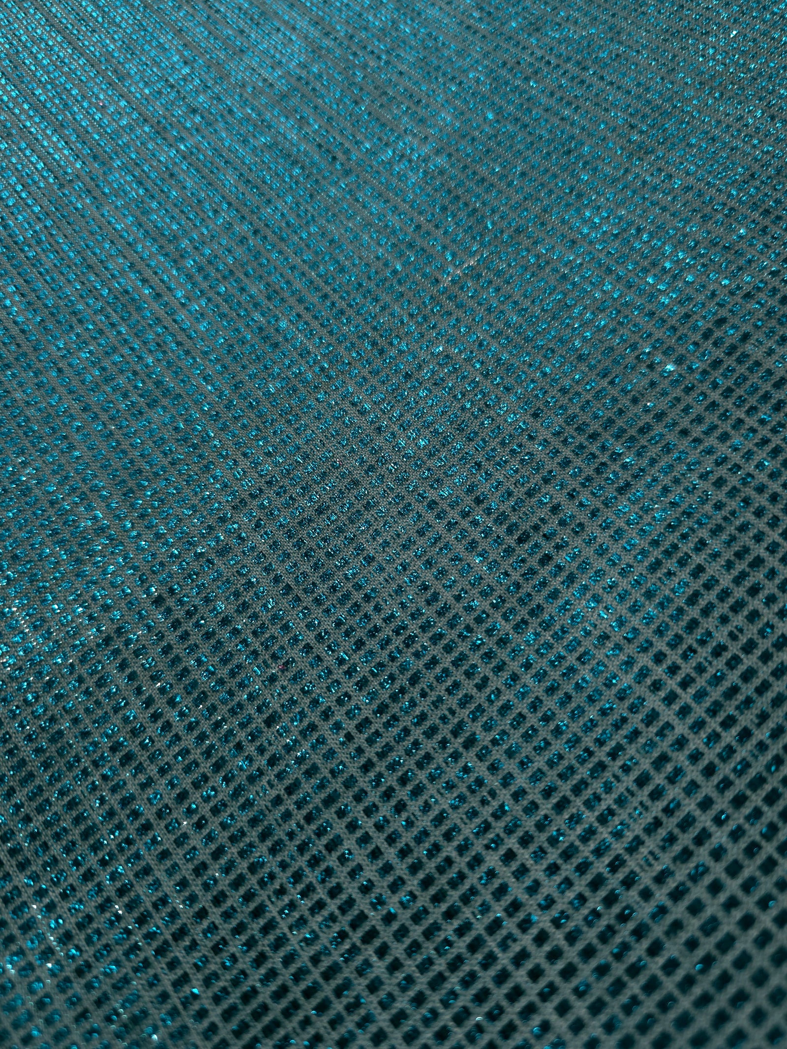 Close-up of Aqua Teal Sheer Square Shimmer Stretch Tulle Fabric revealing the square shimmer repeat and fine transparent mesh