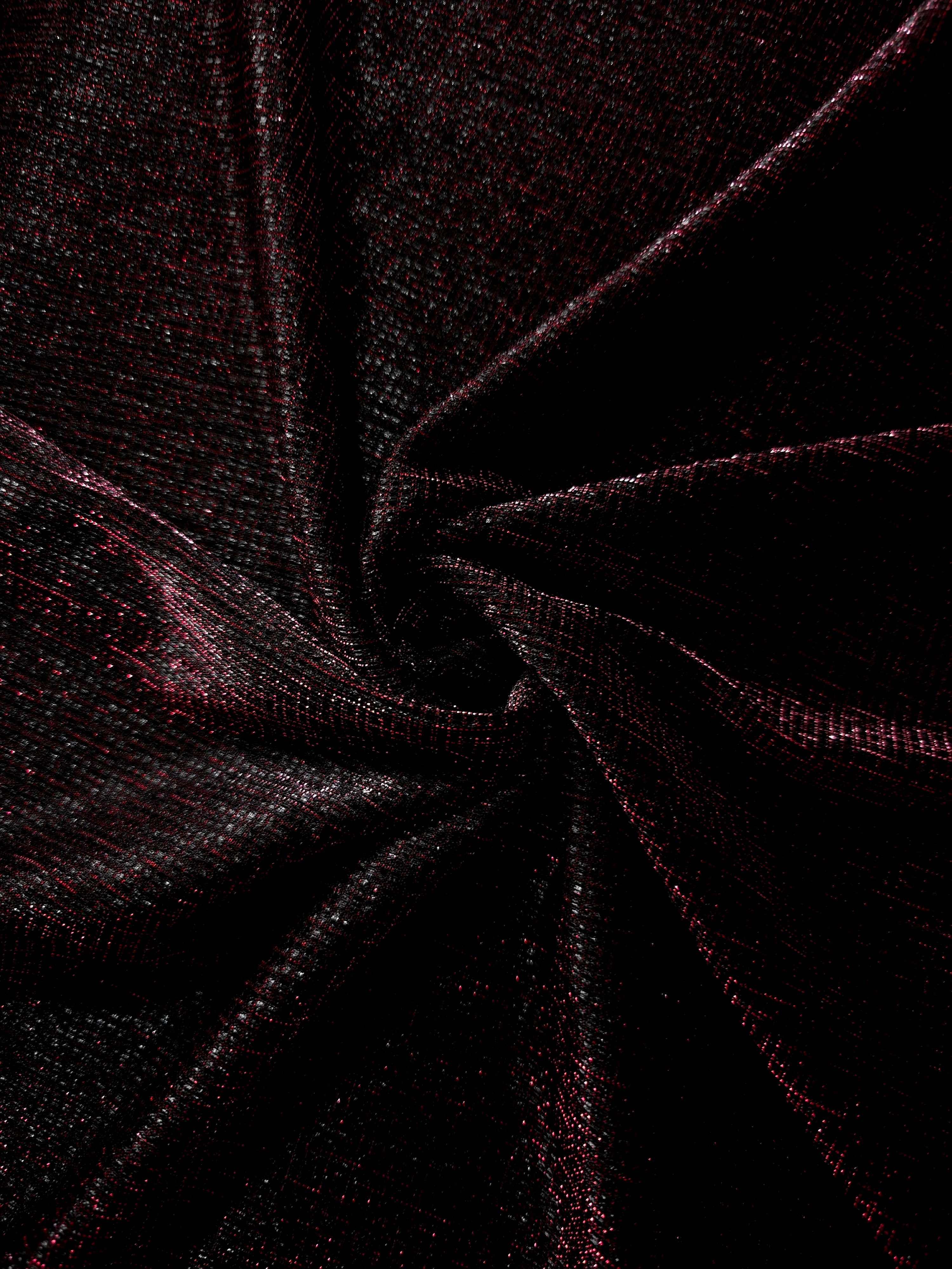 Swirl-draped Black Cherry Sheer Square Shimmer Stretch Tulle Fabric showing structured square reflections moving through soft folds