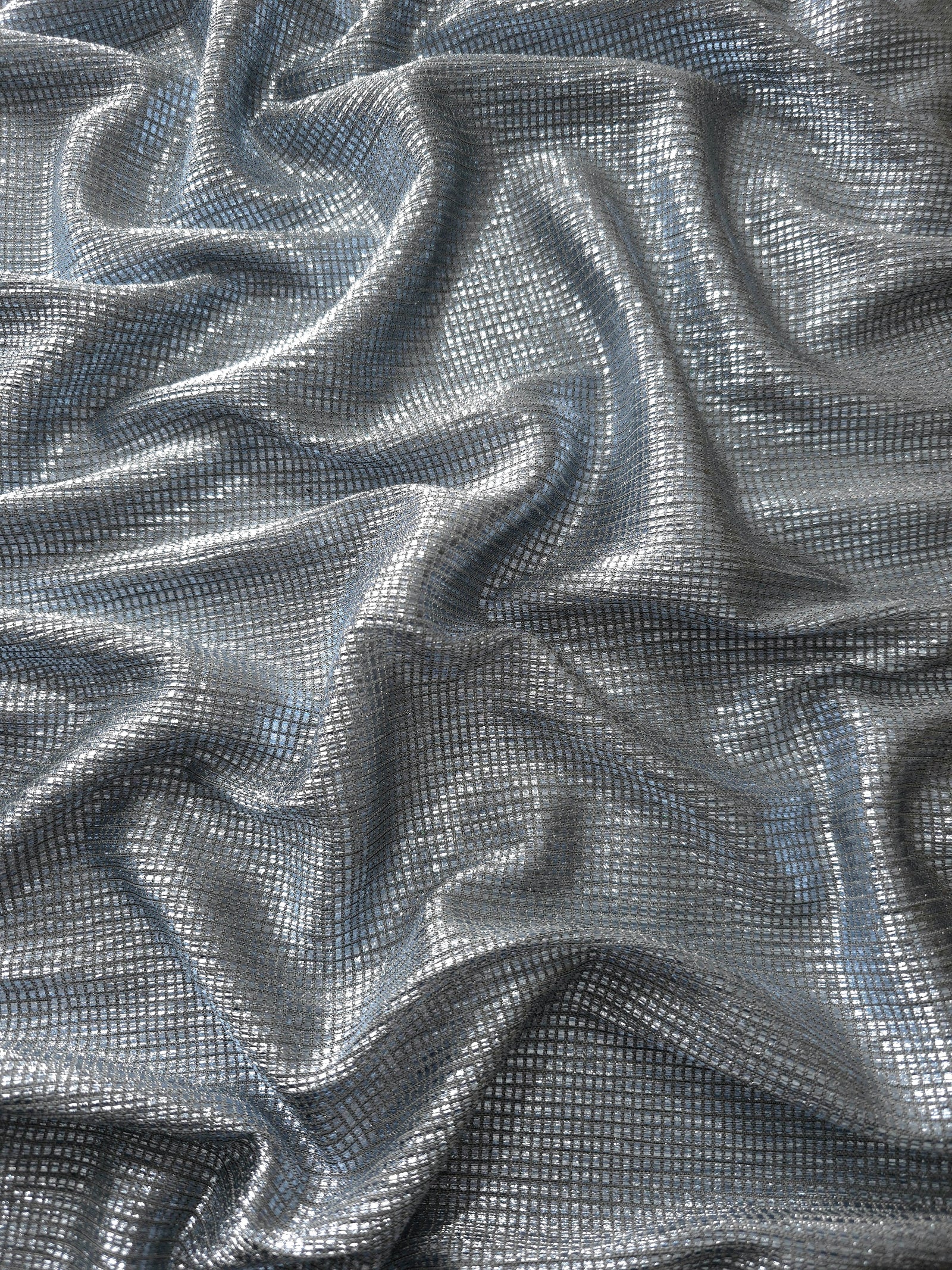 Draped Bright Silver Sheer Square Shimmer Stretch Tulle Fabric showing a geometric reflective grid across fluid folds