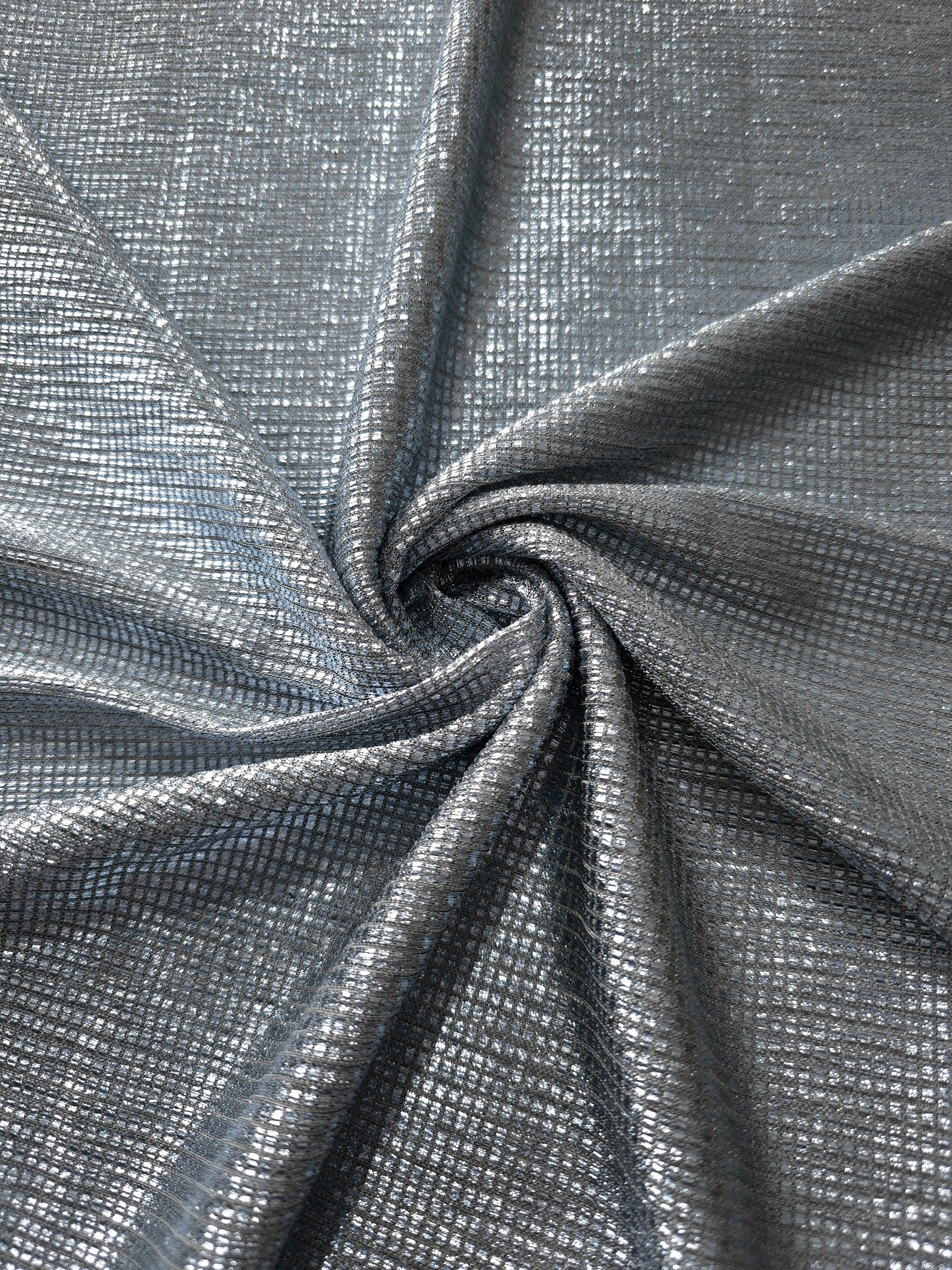 Swirl-draped Bright Silver Sheer Square Shimmer Stretch Tulle Fabric showing structured square reflections moving through soft folds