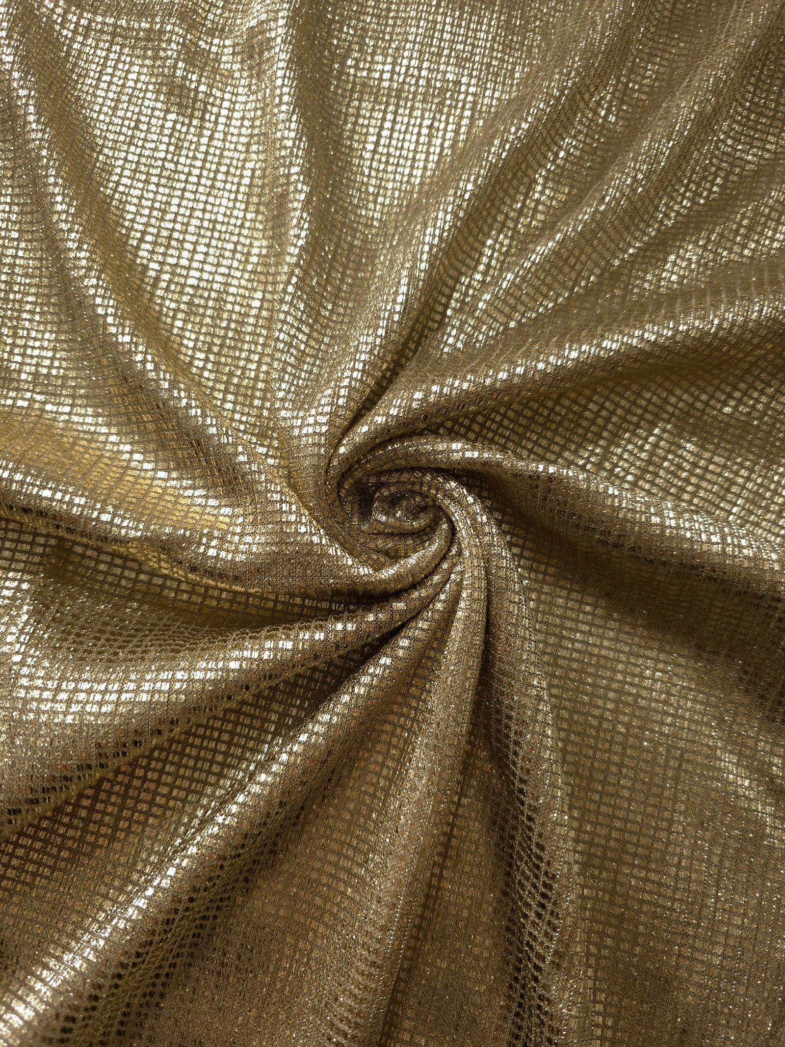 Swirl-draped Champagne Gold Sheer Square Shimmer Stretch Tulle Fabric showing structured square reflections moving through soft folds