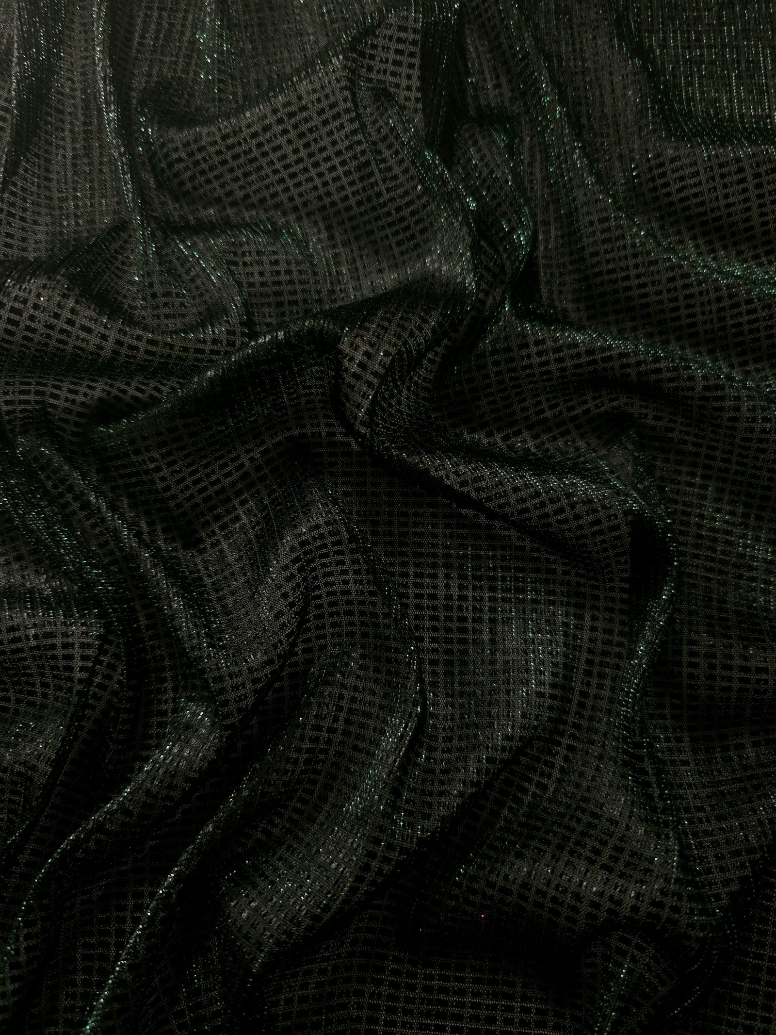 Draped Deep Emerald Sheer Square Shimmer Stretch Tulle Fabric showing a geometric reflective grid across fluid folds