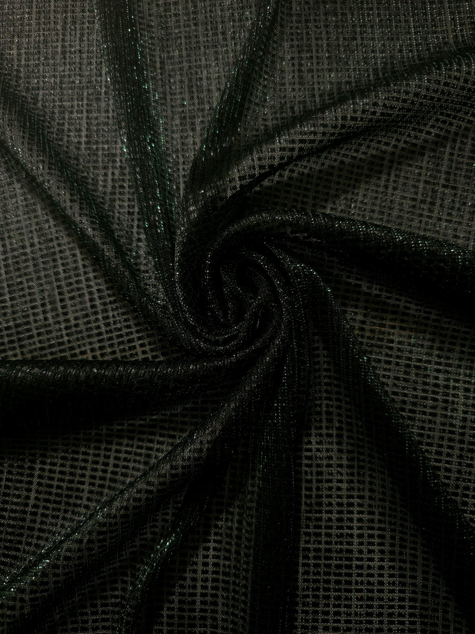Swirl-draped Deep Emerald Sheer Square Shimmer Stretch Tulle Fabric showing structured square reflections moving through soft folds