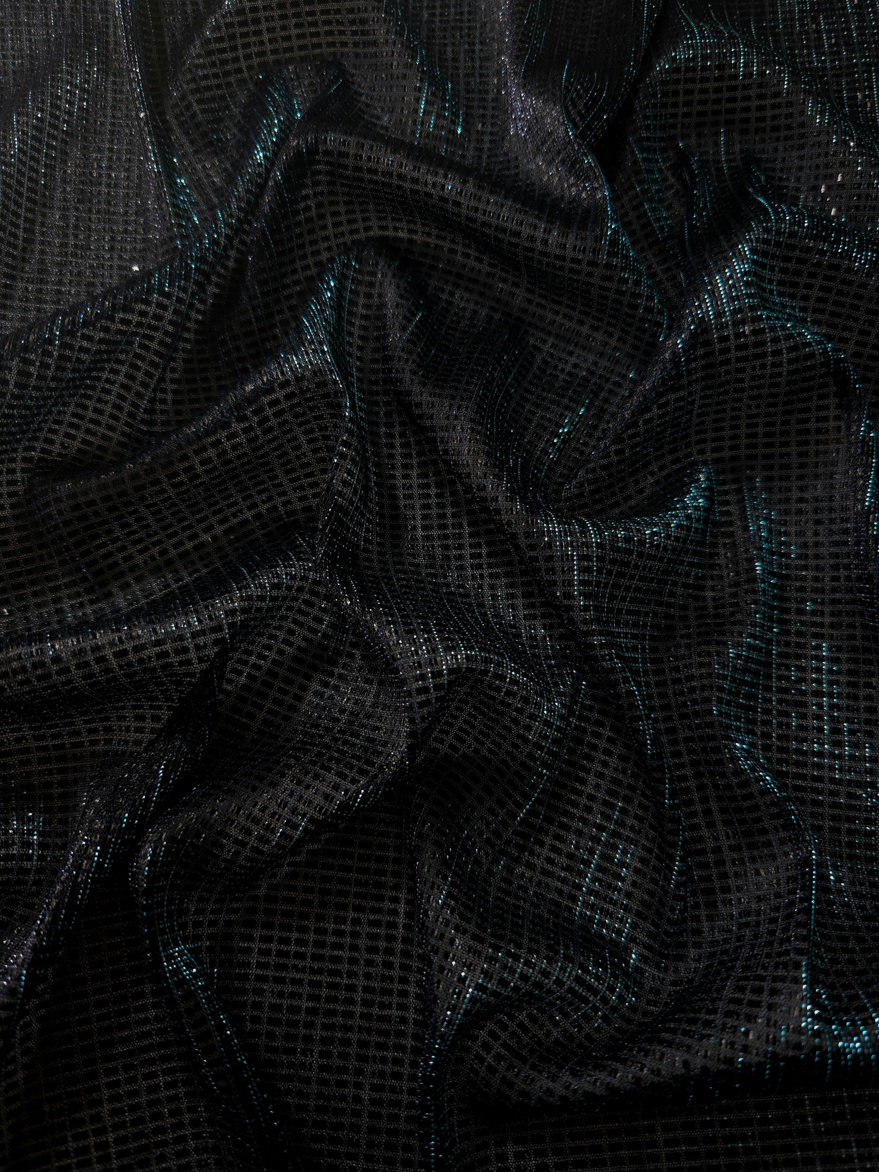 Draped Deep Teal Sheer Square Shimmer Stretch Tulle Fabric showing a geometric reflective grid across fluid folds