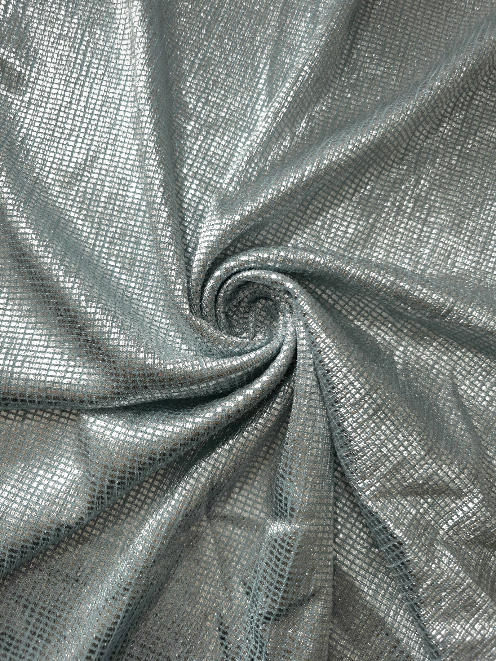 Swirl-draped Icy Silver Sheer Square Shimmer Stretch Tulle Fabric showing structured square reflections moving through soft folds