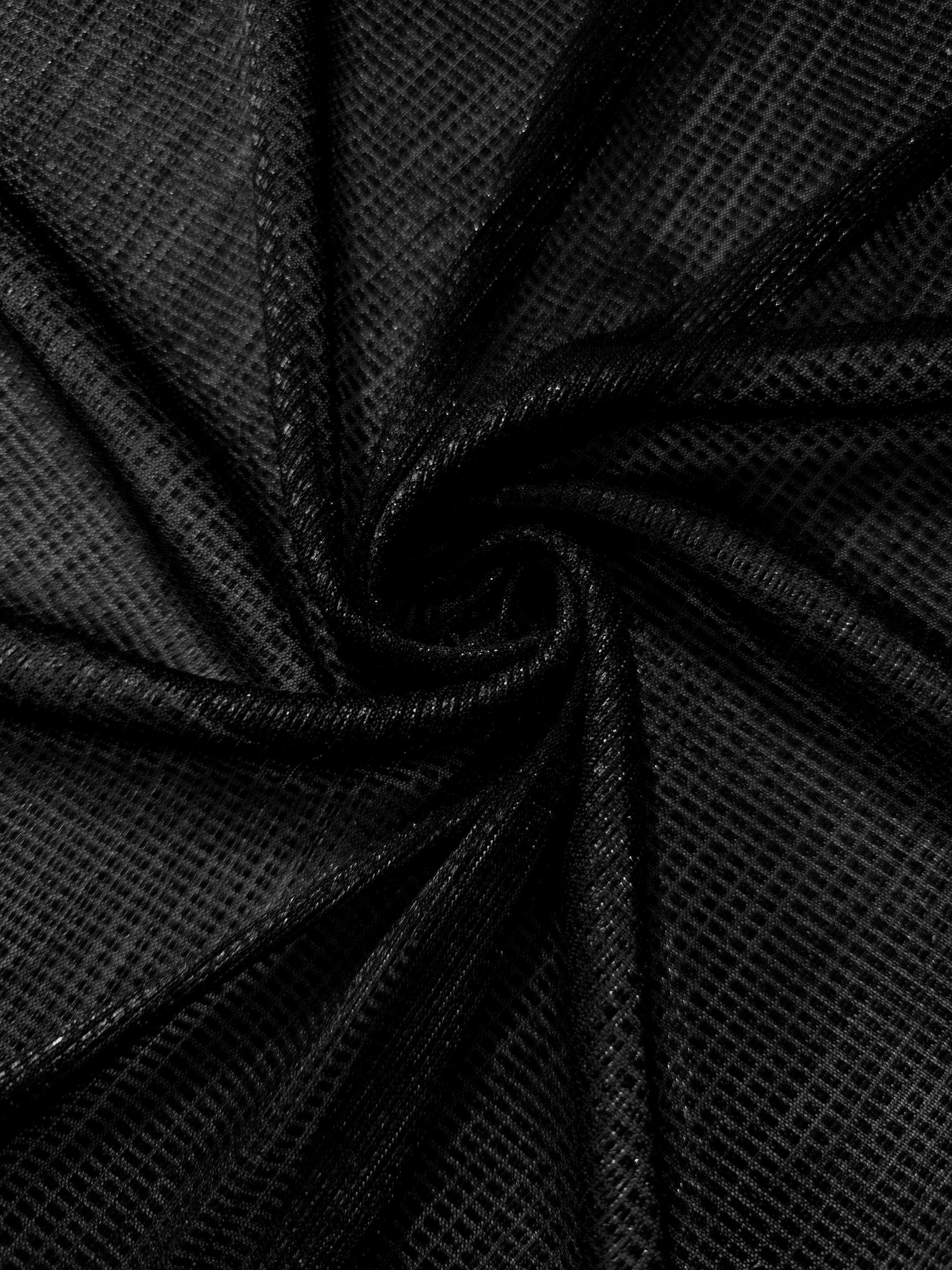 Swirl-draped Jet Black Sheer Square Shimmer Stretch Tulle Fabric showing structured square reflections moving through soft folds