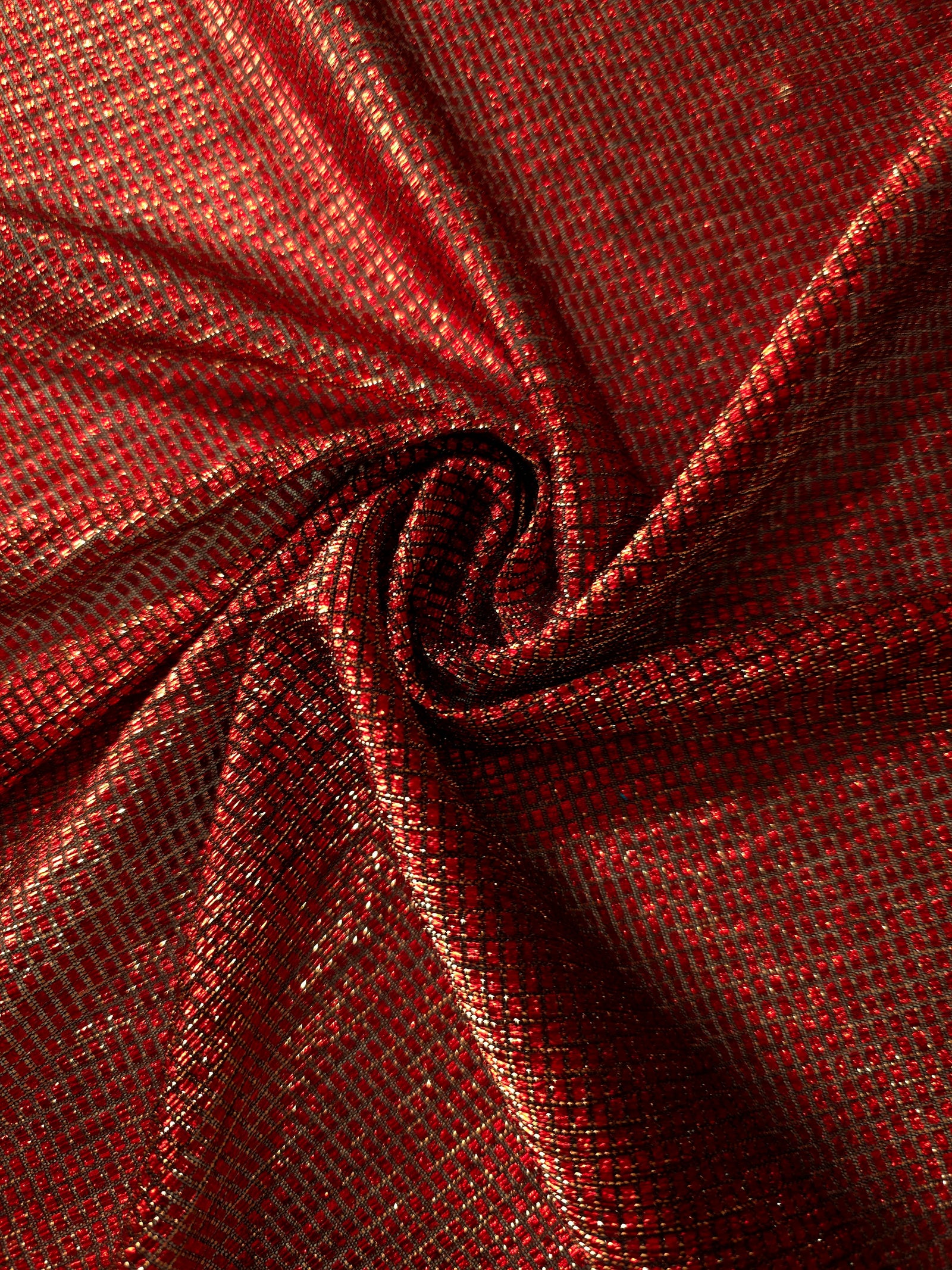 Swirl-draped Ruby Red Sheer Square Shimmer Stretch Tulle Fabric showing structured square reflections moving through soft folds