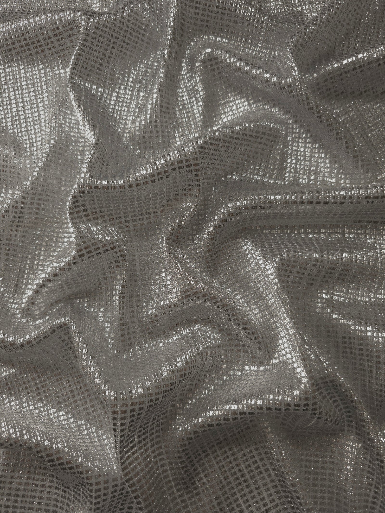 Draped Silver Gray Sheer Square Shimmer Stretch Tulle Fabric showing a geometric reflective grid across fluid folds