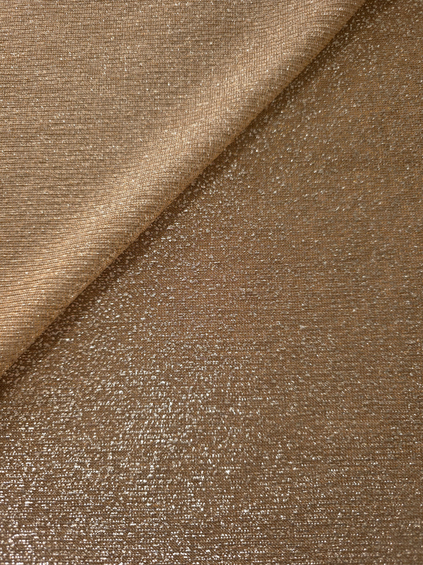 Front and back of Antique Gold Sheer Glitter Stretch Tulle Fabric showing transparent knit construction and flexible 4-way stretch