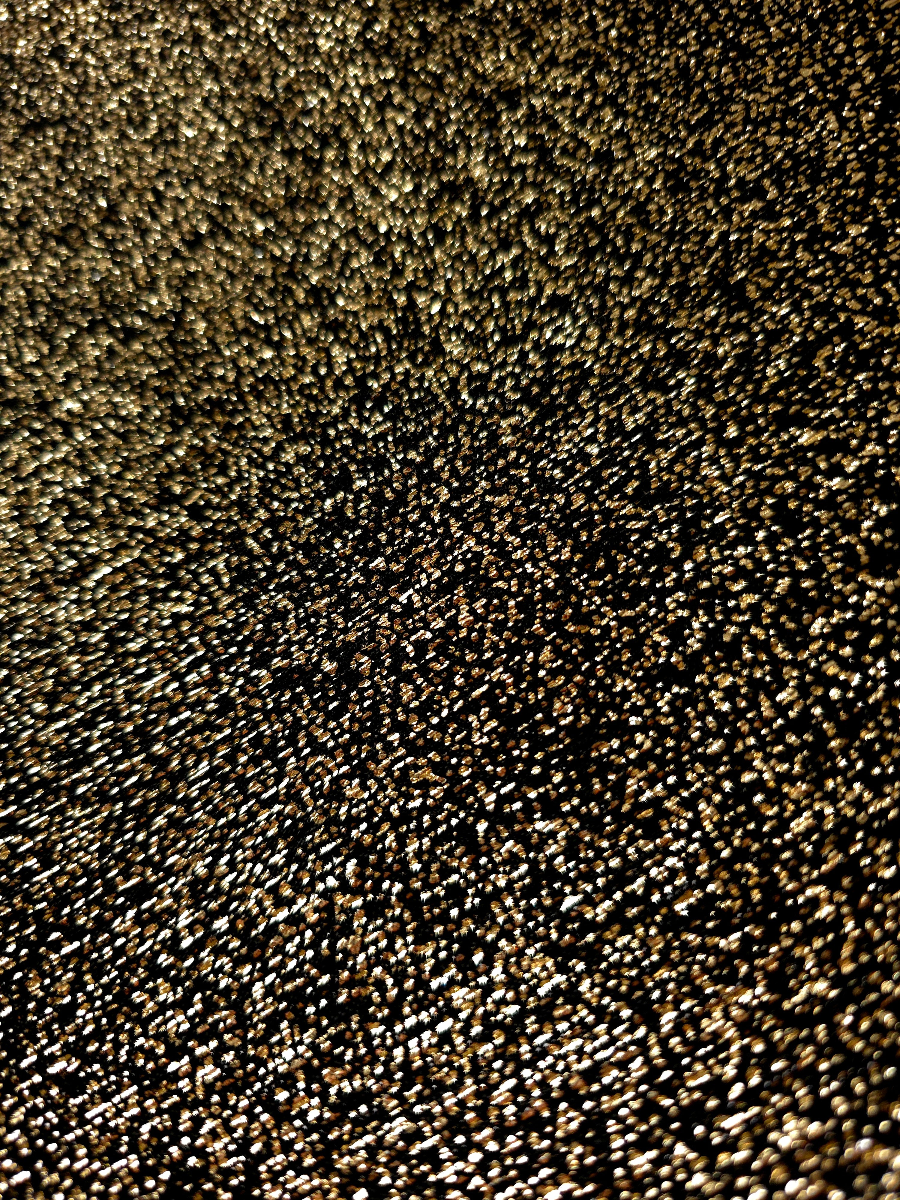Close-up of Black Gold Sheer Glitter Stretch Tulle Fabric highlighting all-over glitter, fine mesh texture and airy transparency
