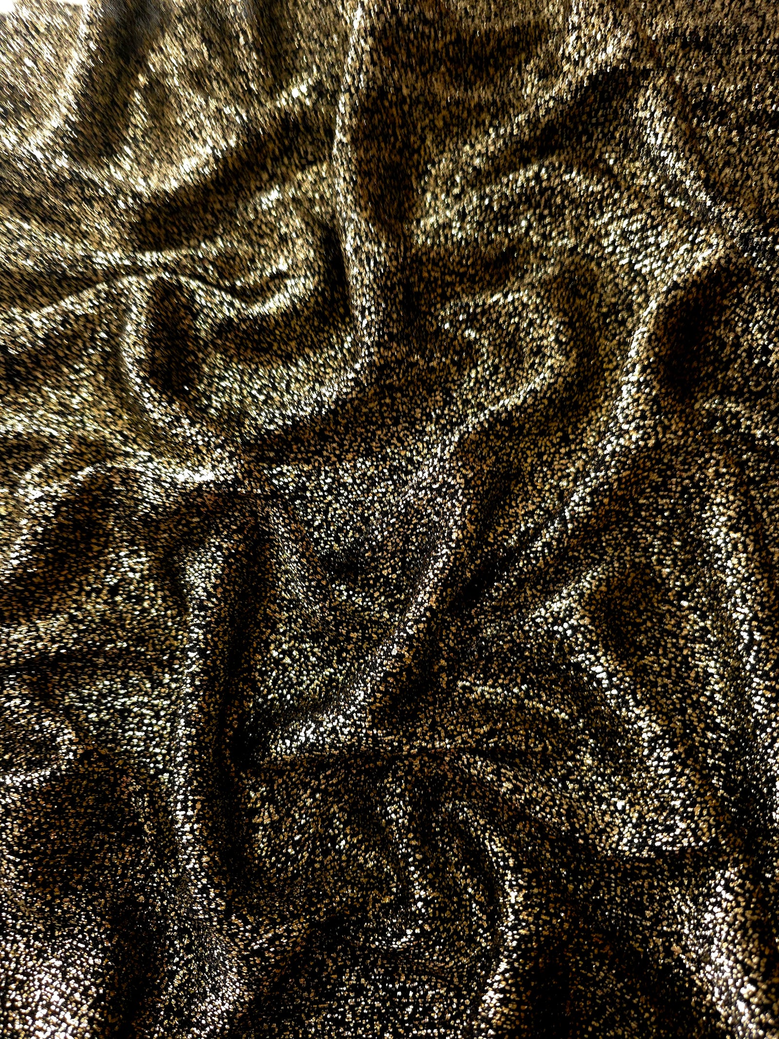 Draped Black Gold Sheer Glitter Stretch Tulle Fabric showing scattered sparkle across fluid folds for eveningwear and stage looks