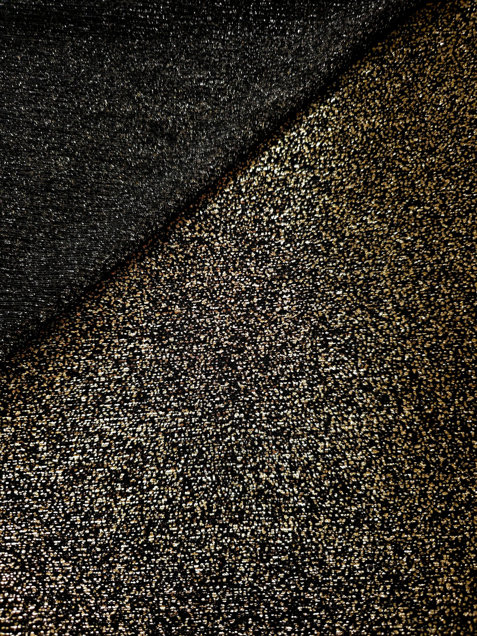 Front and back of Black Gold Sheer Glitter Stretch Tulle Fabric showing transparent knit construction and flexible 4-way stretch