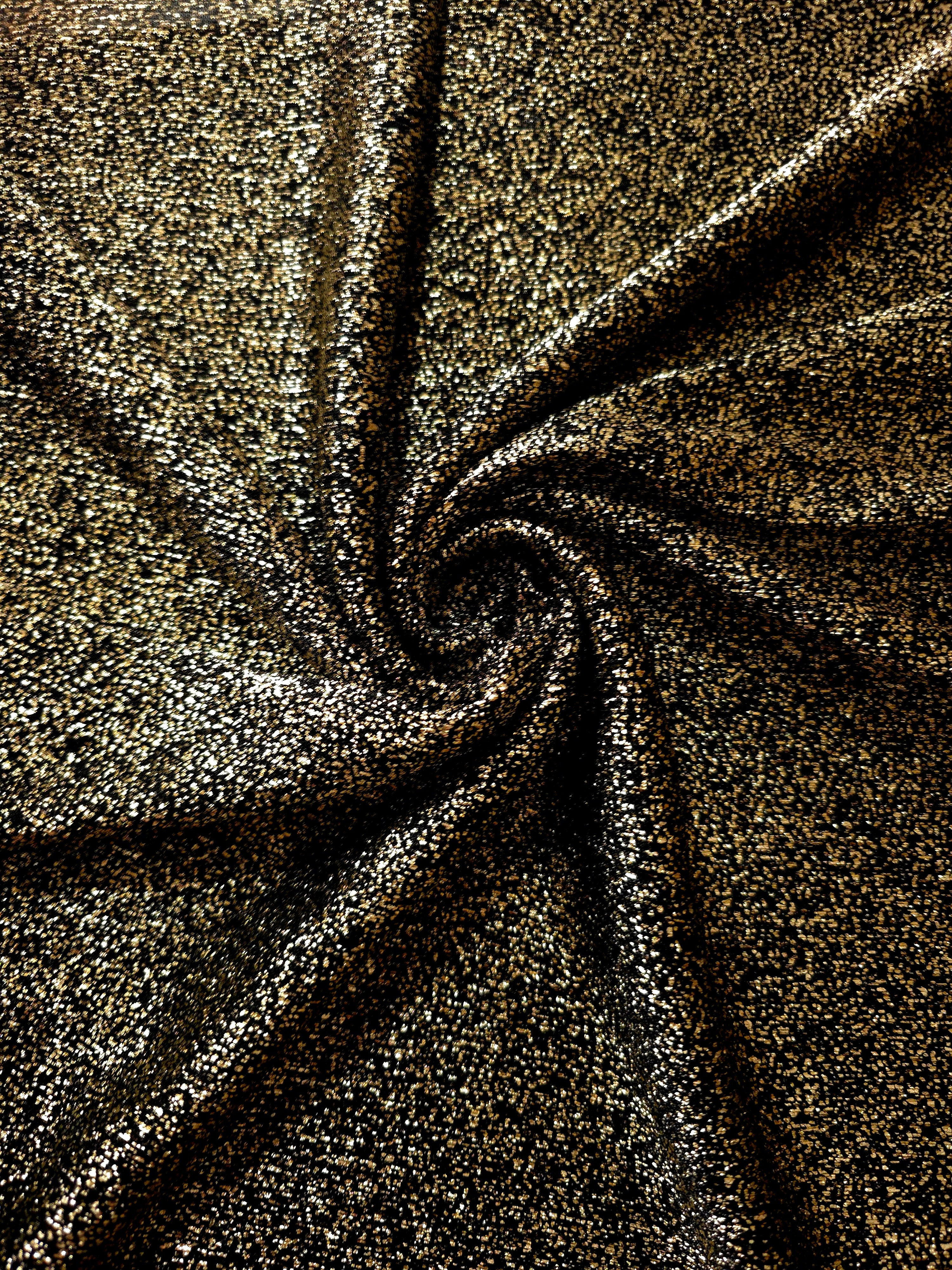 Swirl-draped Black Gold Sheer Glitter Stretch Tulle Fabric capturing reflective sparkle and fluid movement through flexible folds