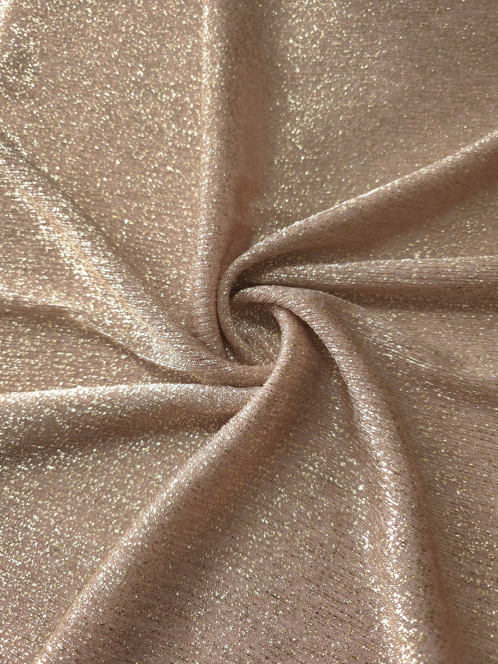 Swirl-draped Champagne Beige Sheer Glitter Stretch Tulle Fabric capturing reflective sparkle and fluid movement through flexible folds