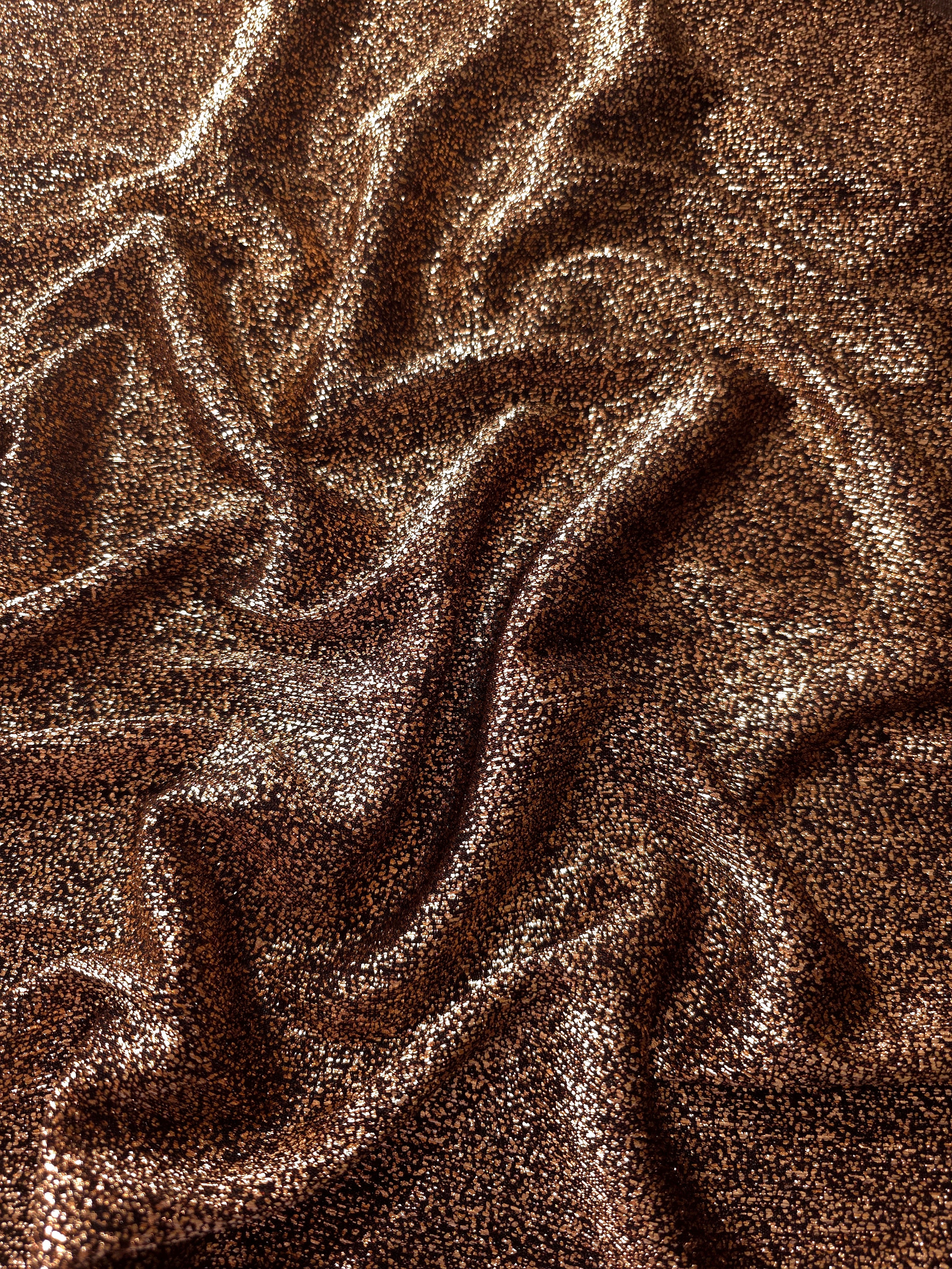 Draped Copper Bronze Sheer Glitter Stretch Tulle Fabric showing scattered sparkle across fluid folds for eveningwear and stage looks